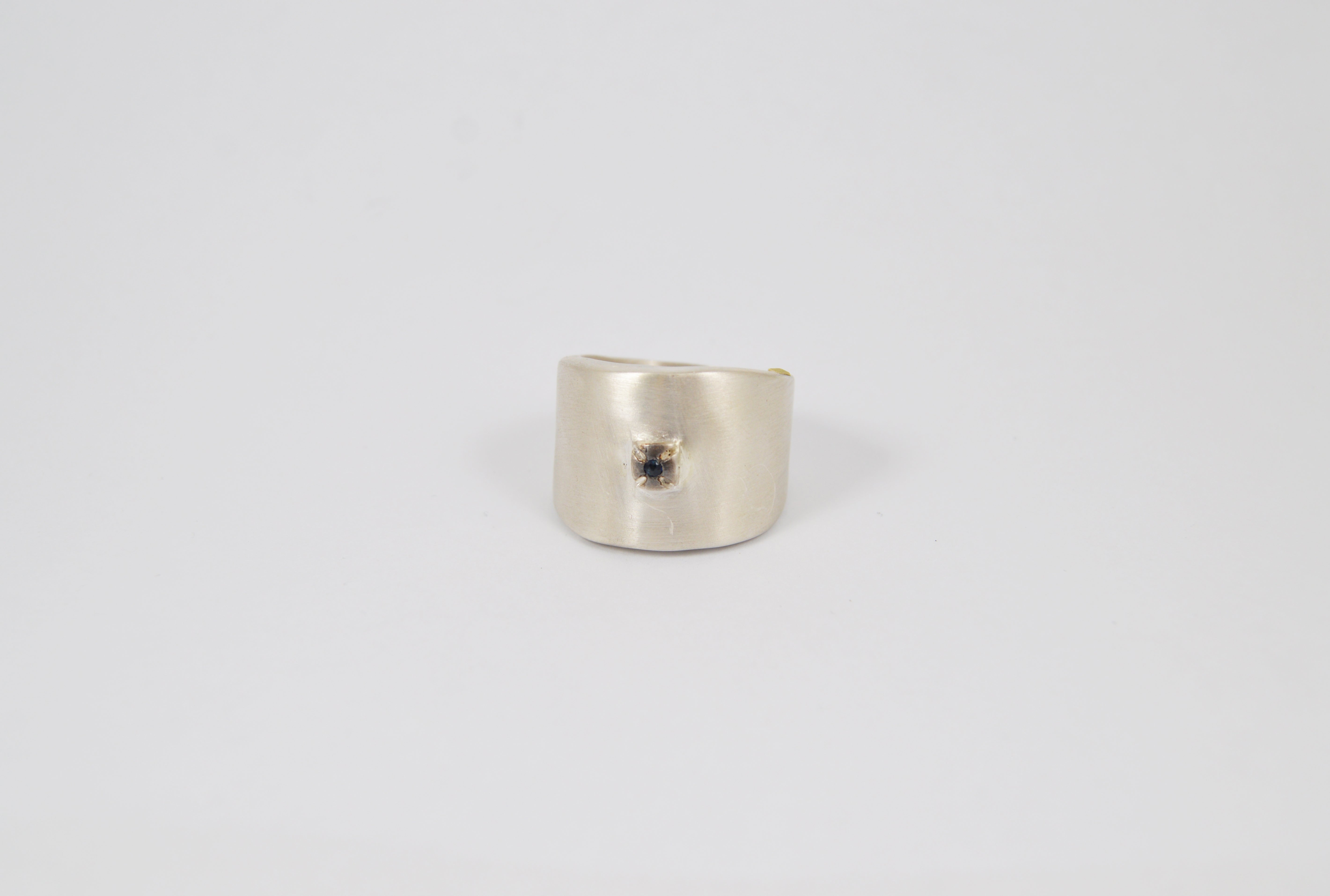 Rosa Maria Kim Ring, frontal view, handcrafted silver band with a raw organic shape and blue sapphire accent.