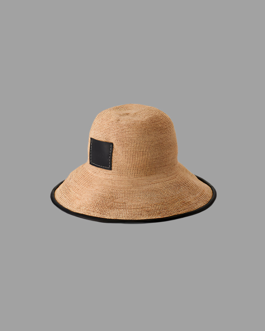 Kijima Takayuki Straw Mushroom Hat side view; handcrafted raffia with black trim and patch, embodying modern elegance.