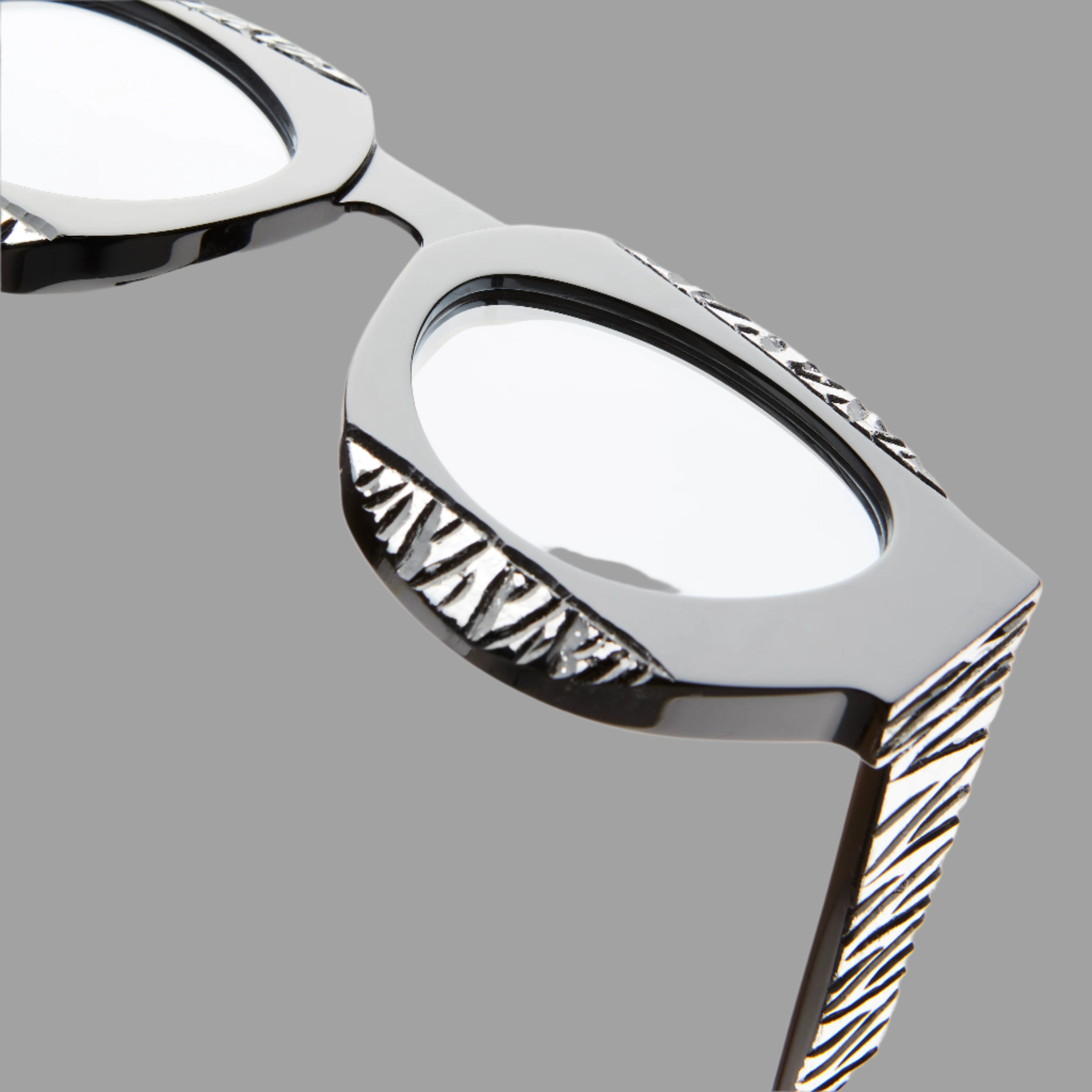 Kuboraum Berlin Mask X22 featuring a close-up of the black acetate frame with intricate silver detailing and clear lenses.