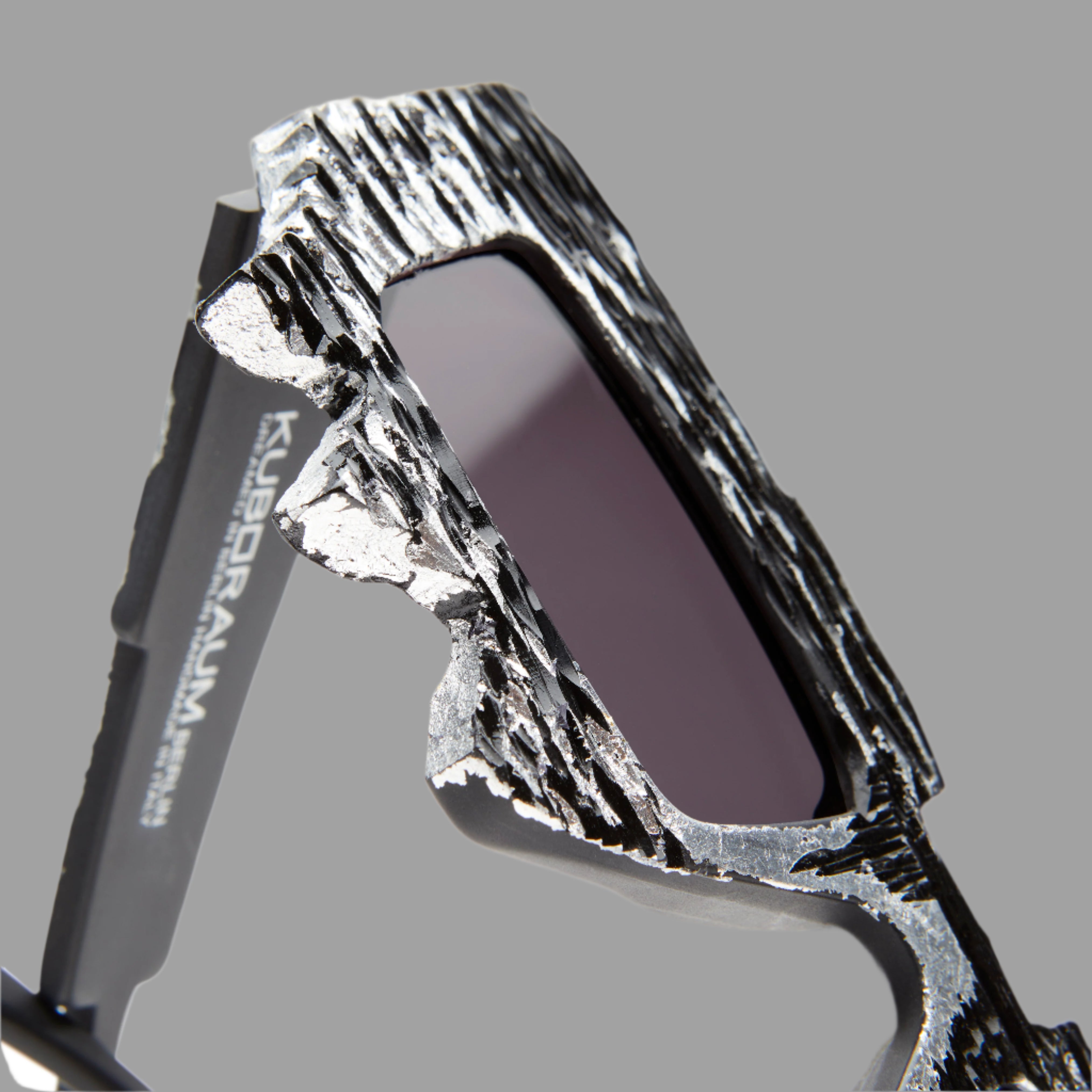 Kuboraum Berlin Mask X6 Black Matte details showcasing a textured silver frame and light grey lenses in close-up.