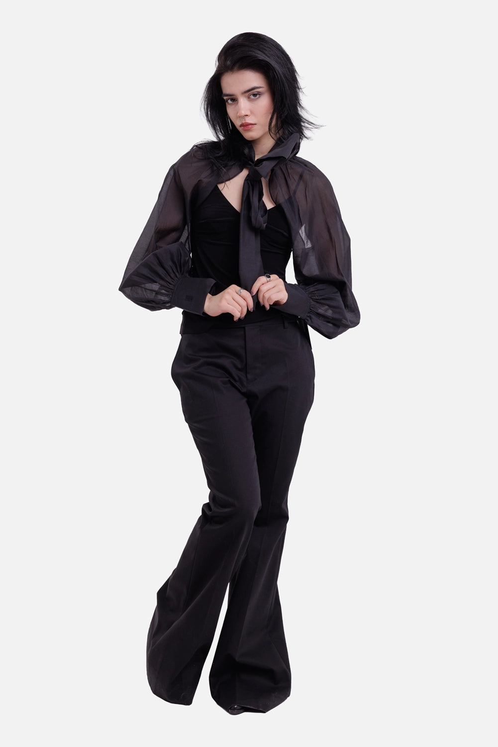 Ann Demeulemeester women's bootcut trousers in black, full-length model view with pressed creases and flared hems