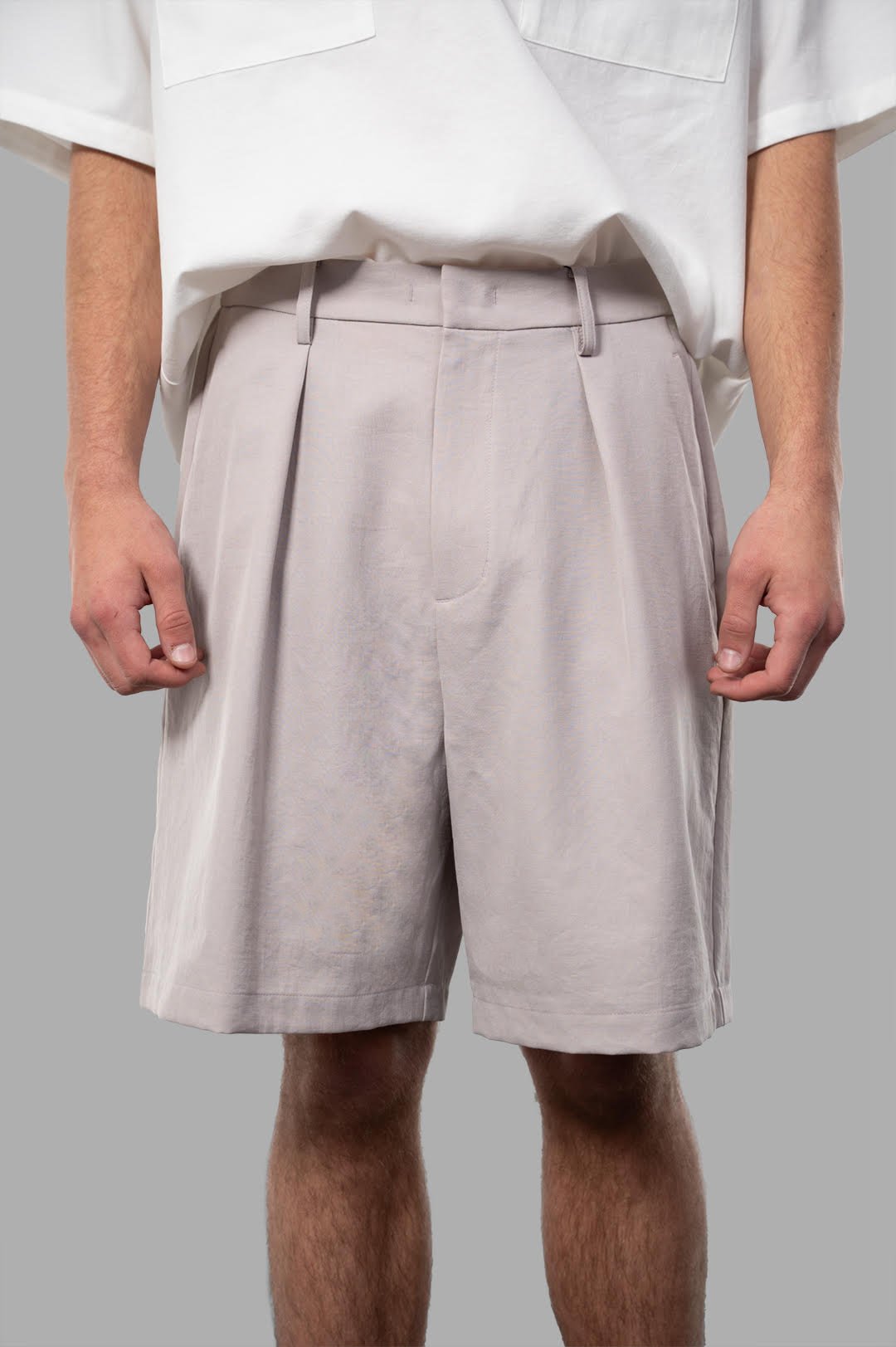 Attachment Twill Shorts in beige, featuring a front view with pleats and an elastic waistband for comfortable wear.