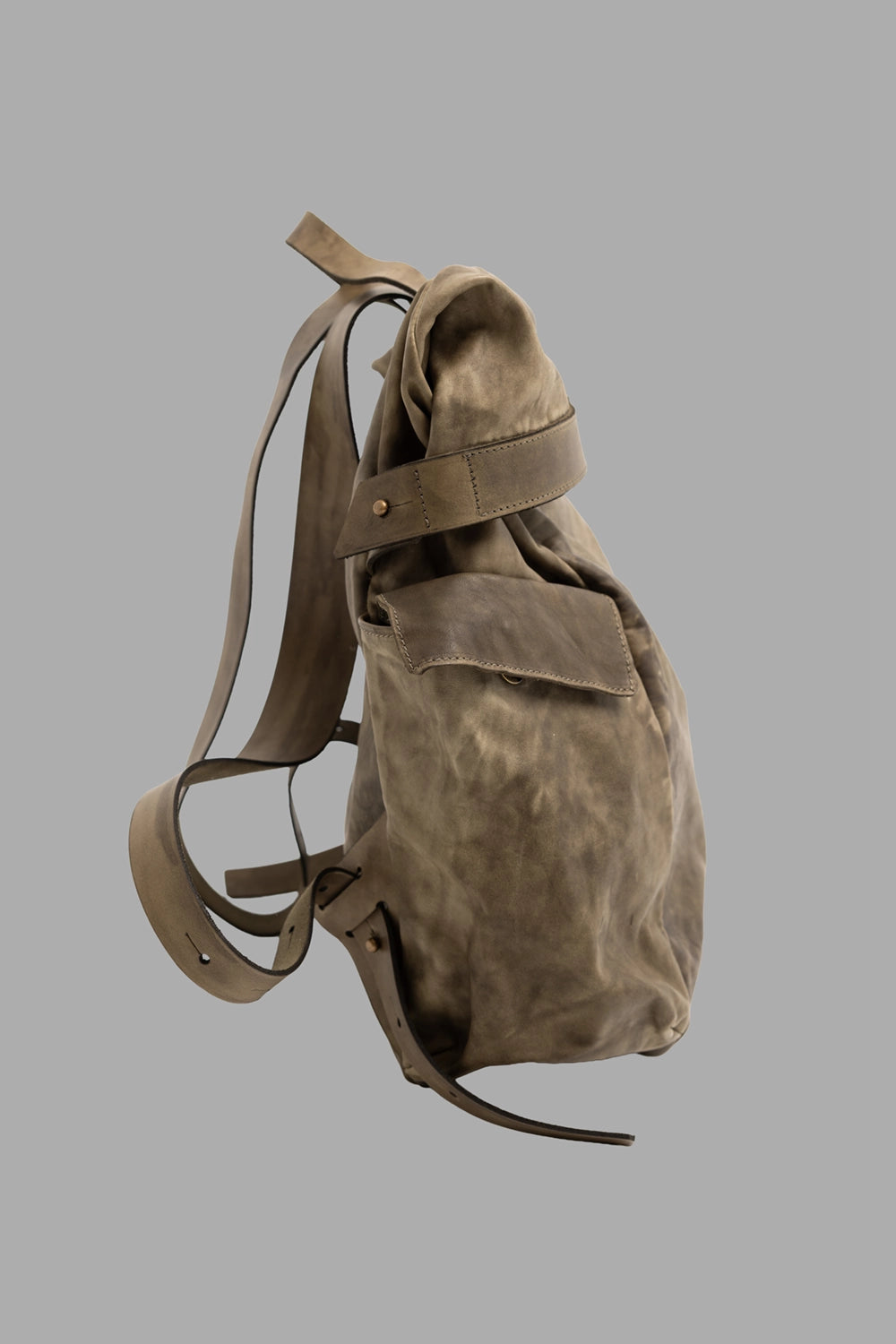 Shoto unisex leather rolltop backpack in dive khaki, side view showing roomy depth and flap pocket with strap detail