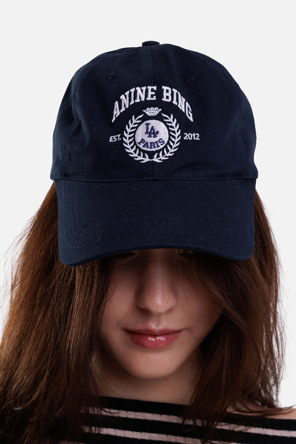 Anine Bing women's blue baseball cap, front on-model view with white collegiate crest embroidery and curved brim