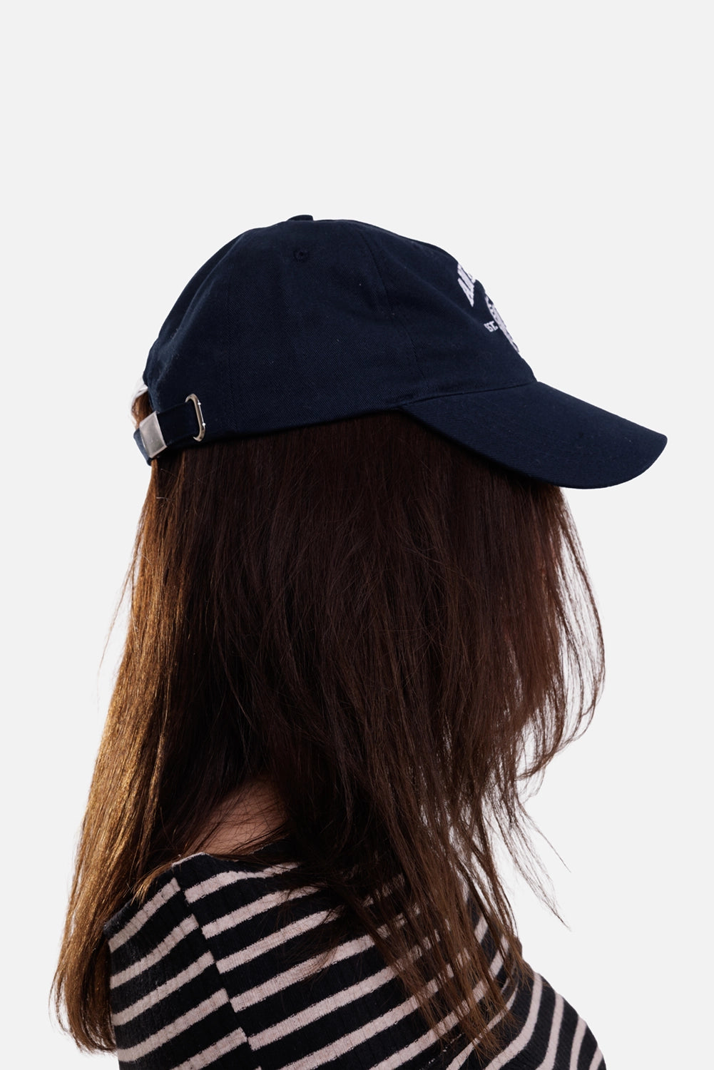 Anine Bing women's blue baseball cap, side on-model view with curved brim and silver adjustable back buckle