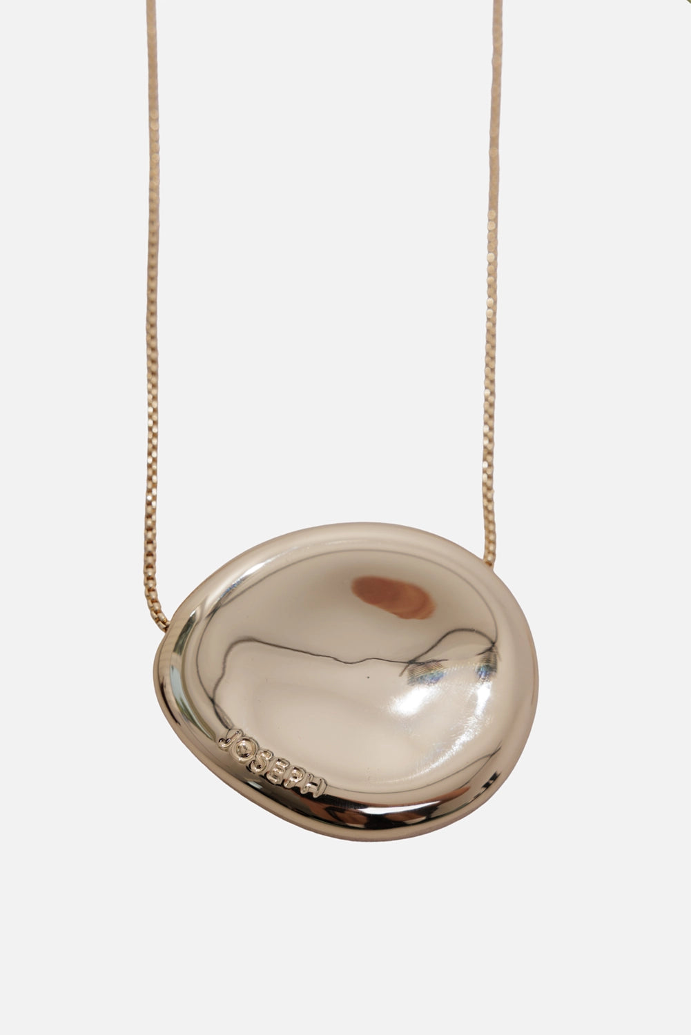 JOSEPH women's Bean pendant necklace in gilded gold, close-up with mirror-polished pendant and logo engraving