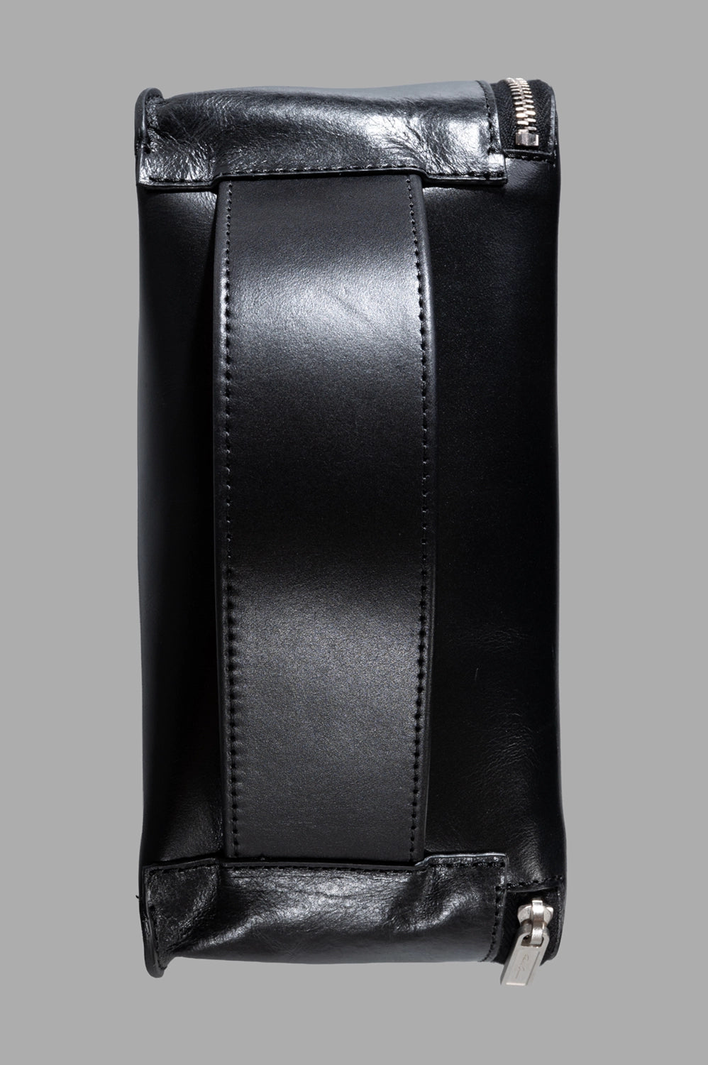 Rick Owens beauty case in black, back view with wide leather handle strap and silver zipper pull