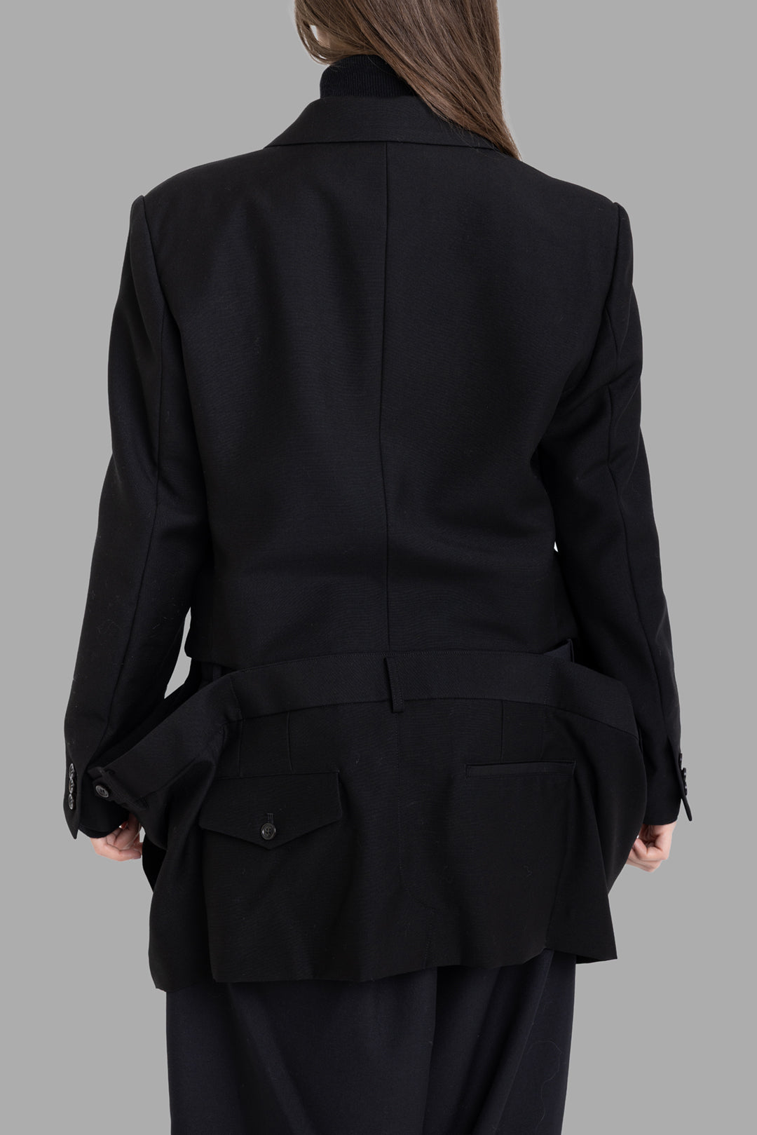 Noir Kei Ninomiya women black blazer, back view, dropped faux trouser waistband with flap pockets