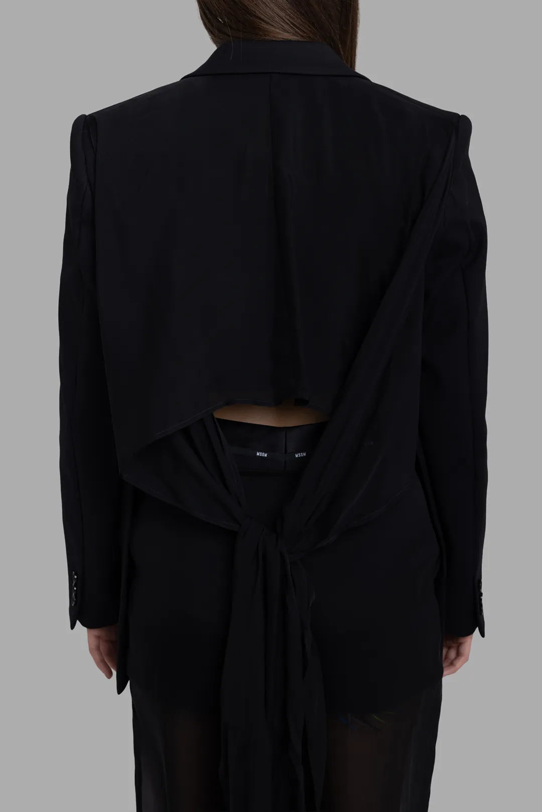 MSGM women's black blazer, back-detail view showing cut-out back and long tie sash at waist