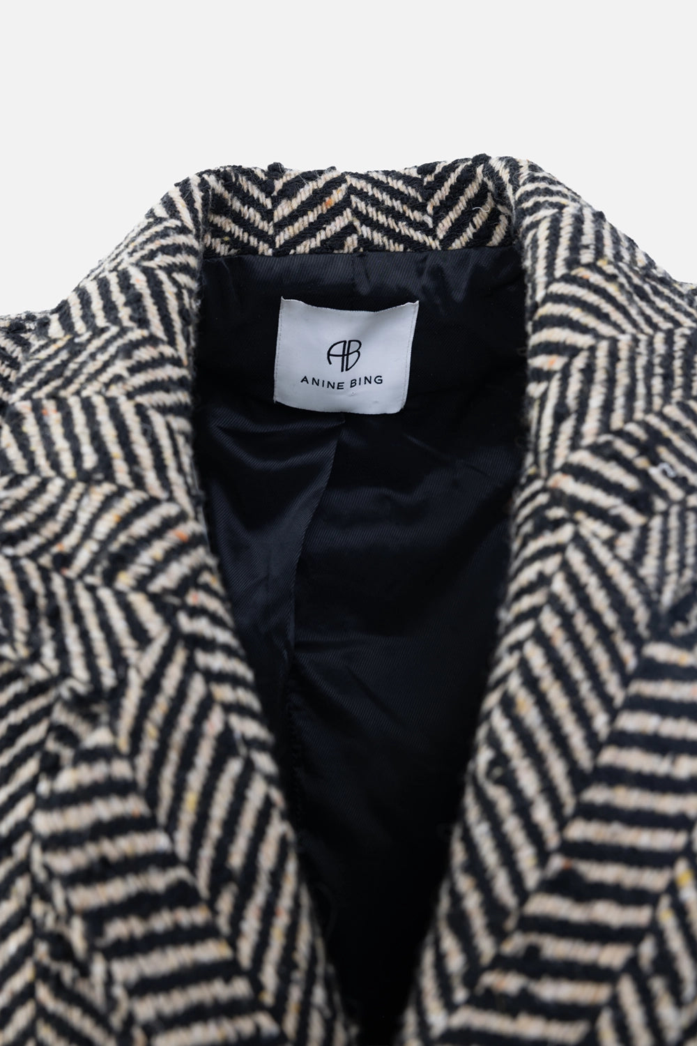 Pre-owned Anine Bing blazer in black and ecru, label close-up, woven herringbone fabric and neck tag