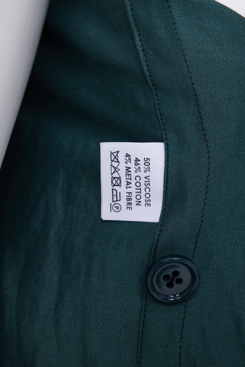 Pre-owned Dries Van Noten blazer in dark green, composition label close-up, fabric percentages and tone button

