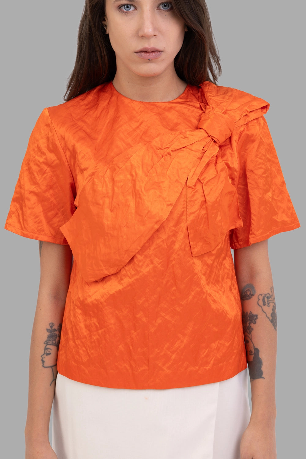 MSGM women bow-front blouse in orange, front view, oversized sculpted bow and round neck.