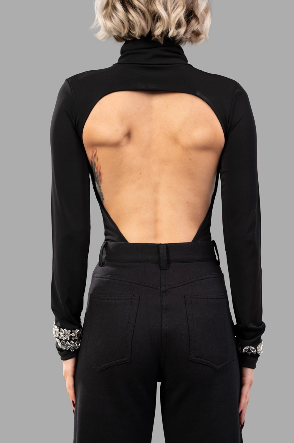 back view of bodysuit showing wide open-back cutout and tall collar