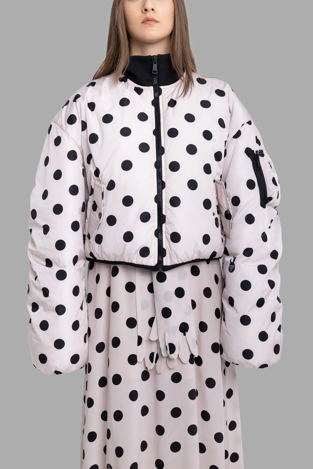 Natasha Zinko women's beige polka dot bomber jacket front view with black bow at collar and padded sleeves.