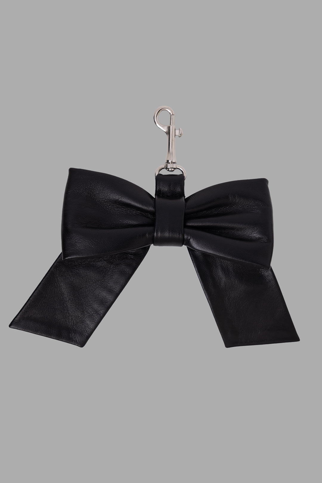 Natasha Zinko leather bow bag charm in black, front view showing padded bow shape and silver clasp