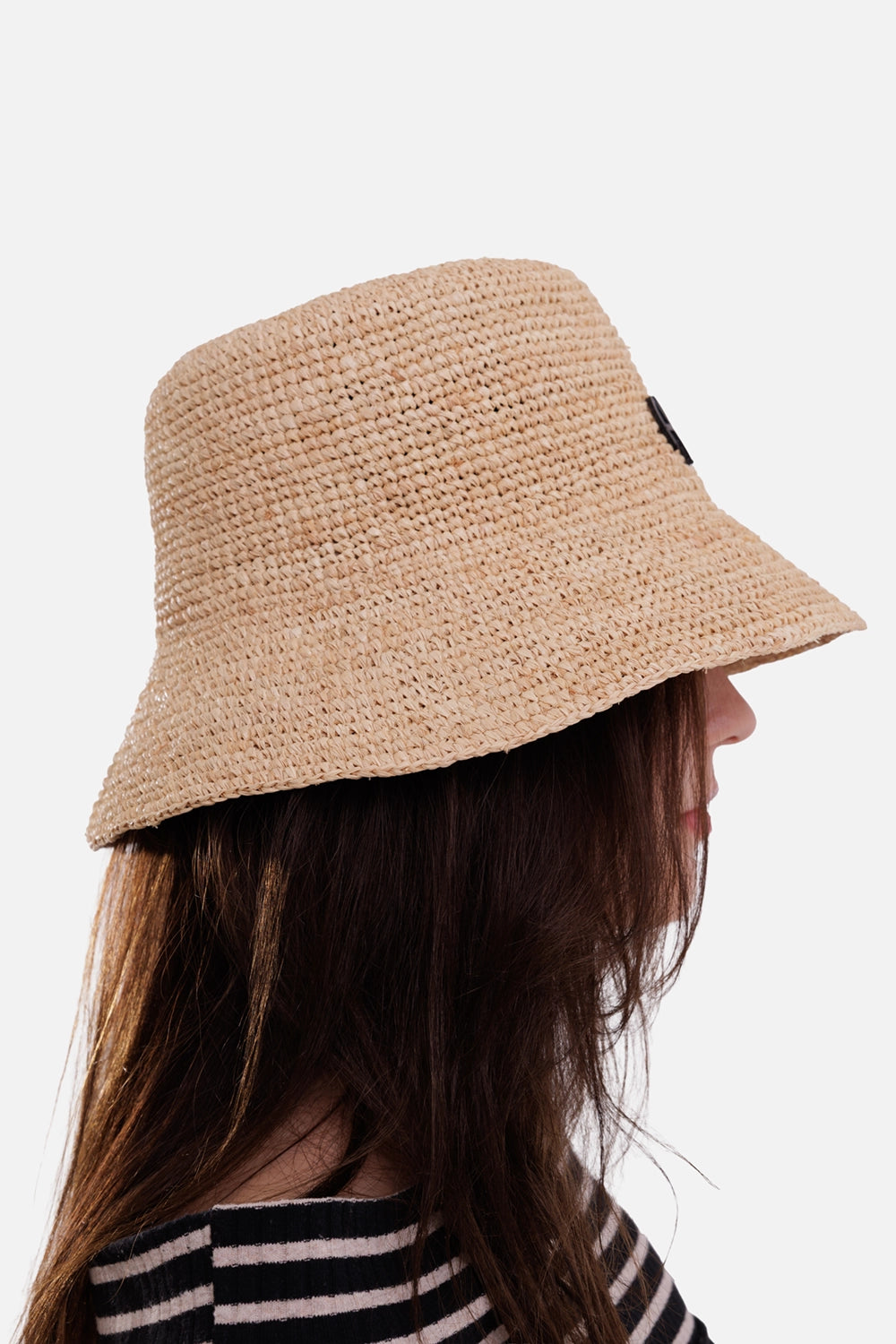 Anine Bing women's beige raffia bucket hat, on-model side view with woven texture and extended rear brim