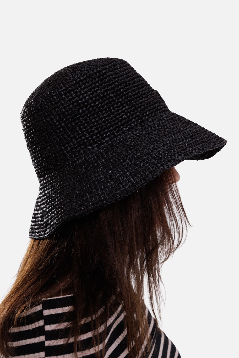 Anine Bing women's black raffia bucket hat, on-model side view showing woven texture and extended rear brim