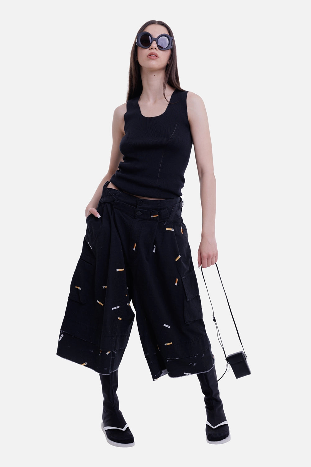 Natasha Zinko women's black cargo shorts, model view with cigarette print and wide layered legs