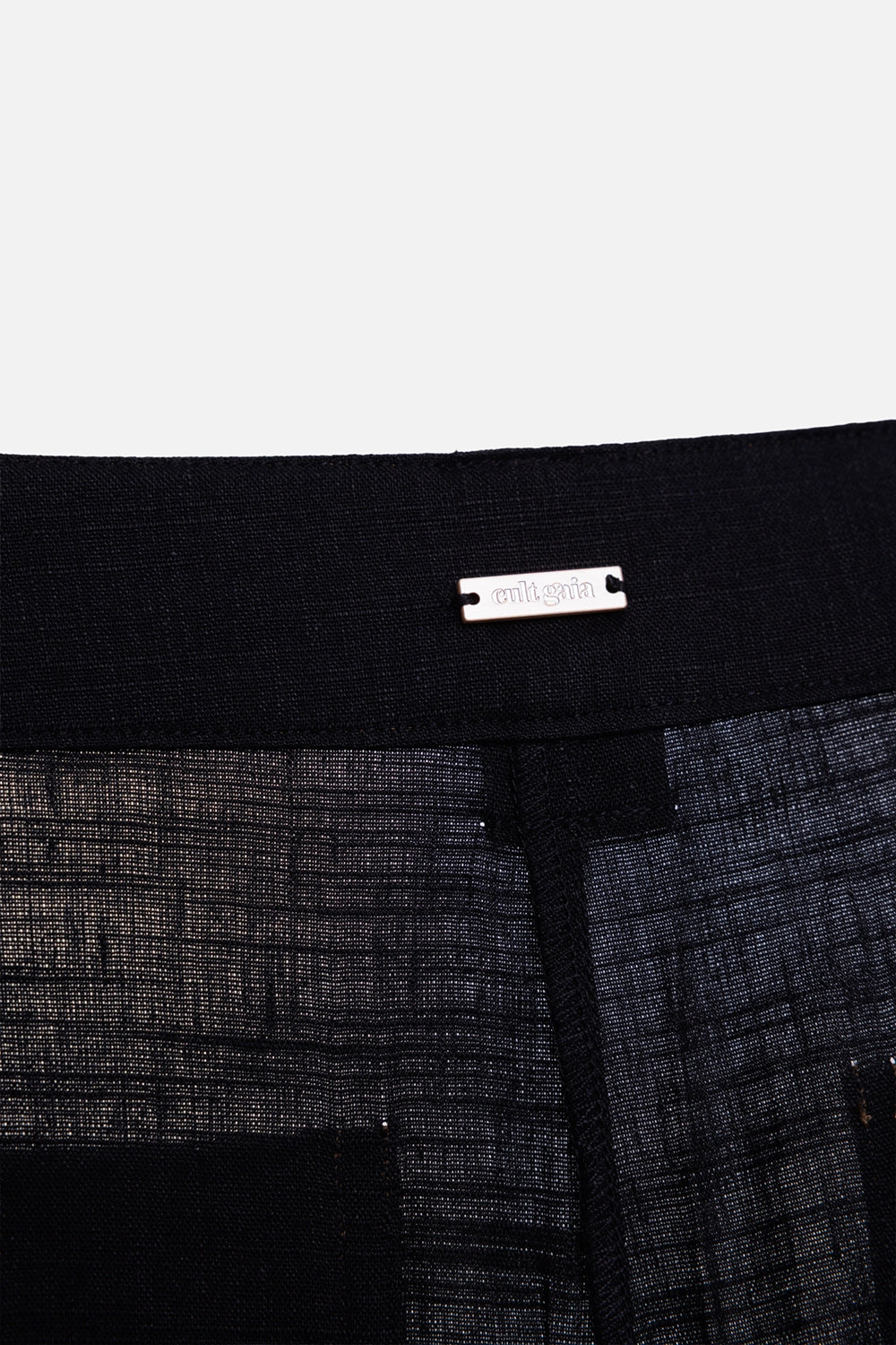 Cult Gaia women cargo trousers in black, label view, silver logo plaque on inner waistband