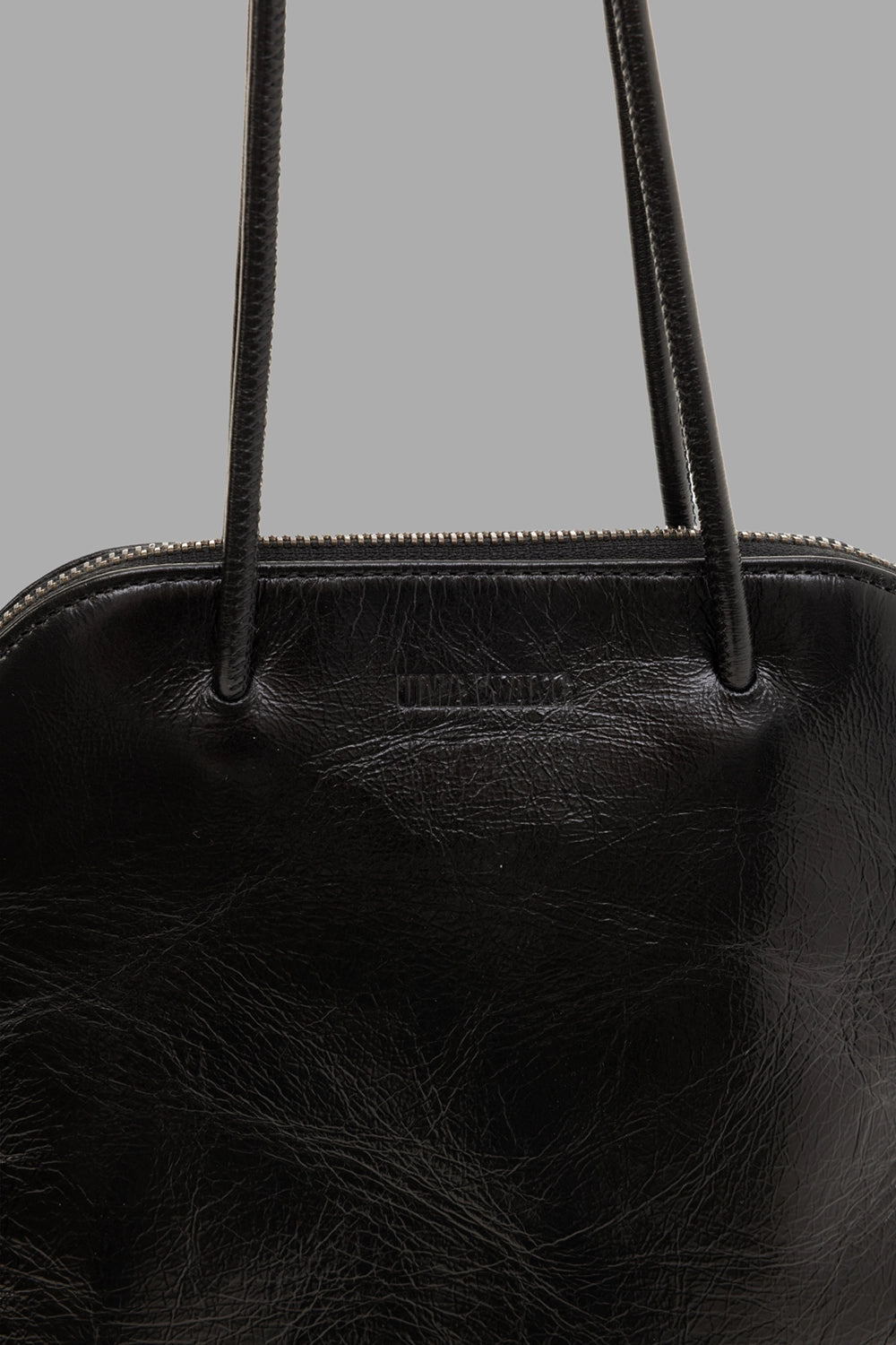 Uma Wang women’s clutch bag in black, logo detail view, debossed front branding and top zip with slim handles