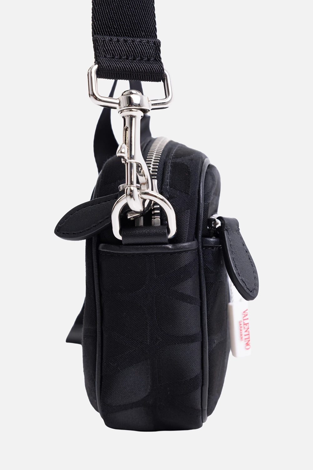 Pre-owned Valentino Garavani men’s crossbody bag in black, side view, silver-tone clip hardware and leather trim