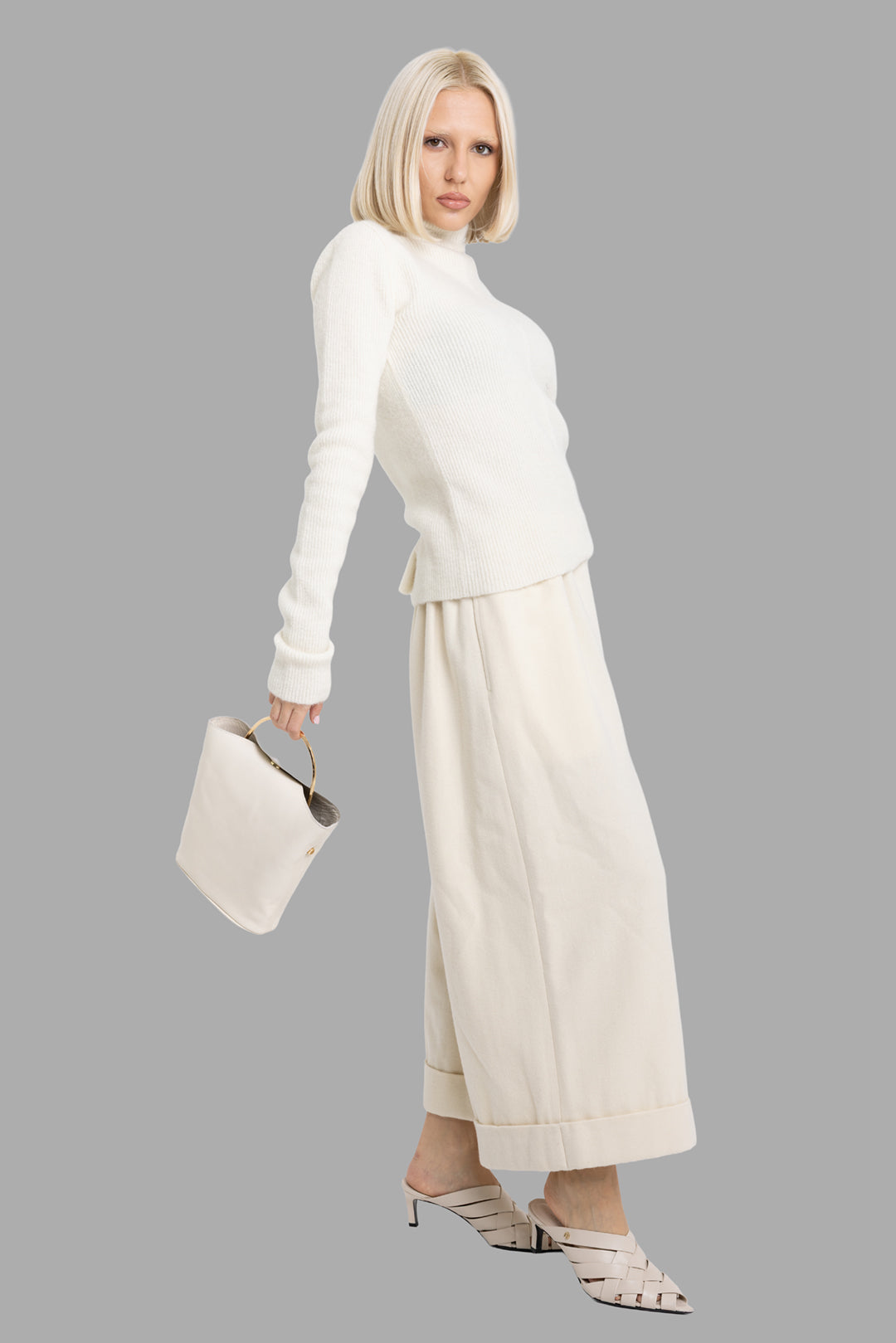 Comme des Garçons women's ivory wool culottes, on-model full-length side view, wide cropped leg with deep cuff.