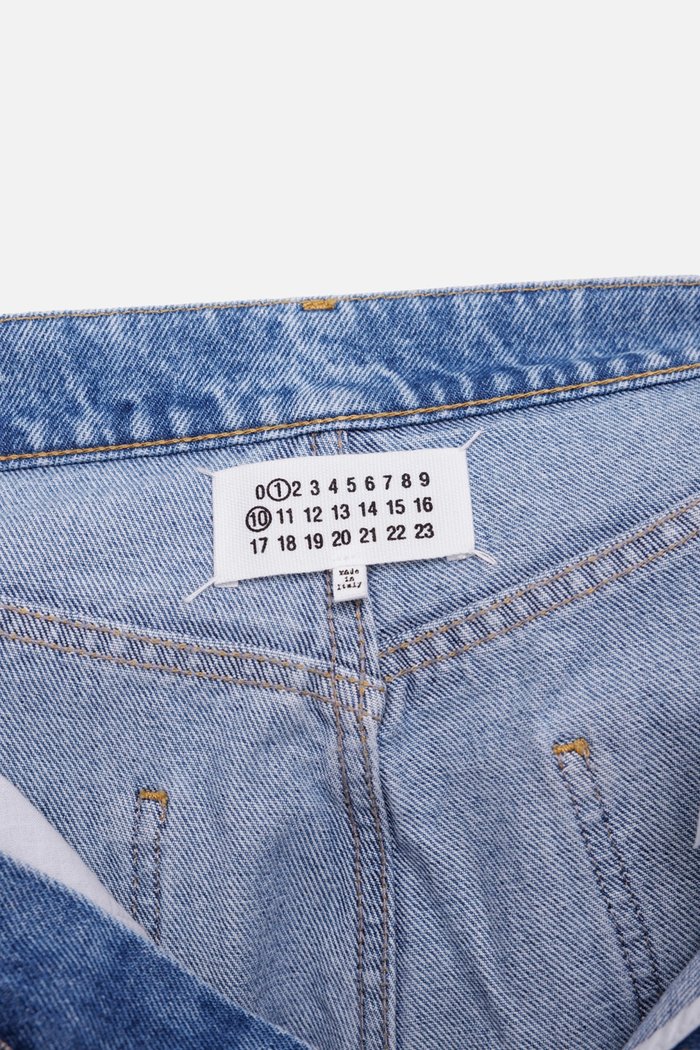 Maison Margiela women's cut-out wide-leg jeans in washed indigo, label detail with numeric tag
