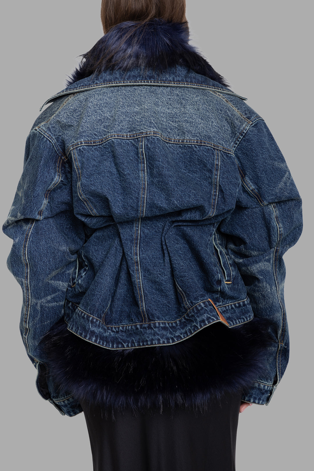 Natasha Zinko women's light wash denim jacket with black faux fur hem, back view, cinched pleated waist and volume