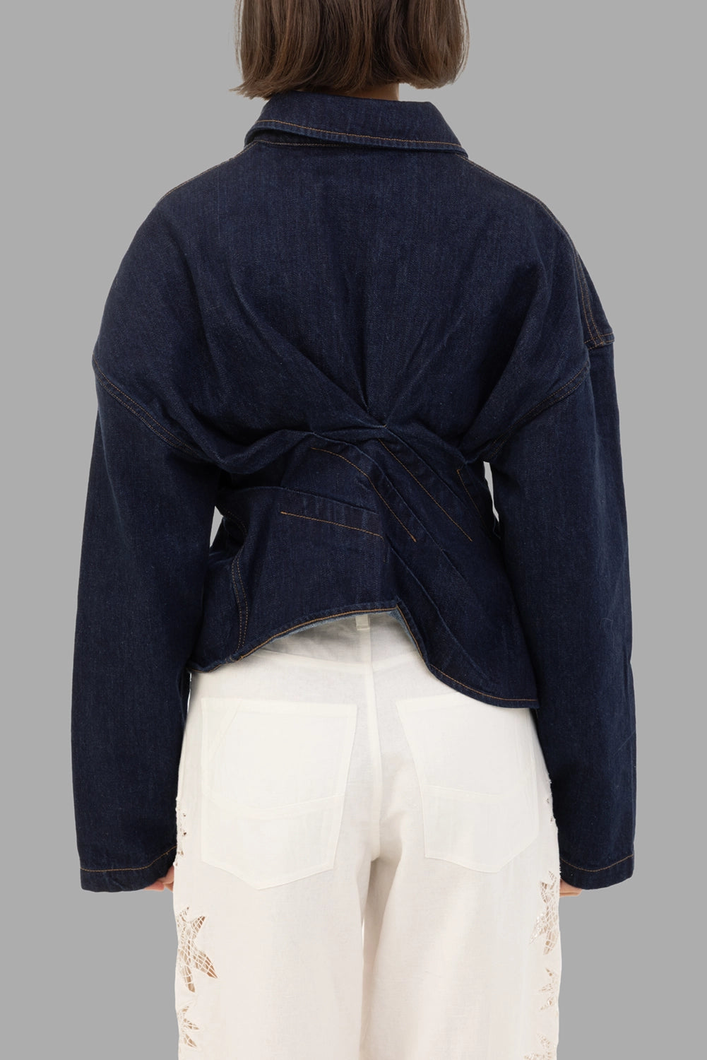 A.W.A.K.E. MODE women's denim shirt in indigo rinse wash, back view, twisted waist with angled pleats