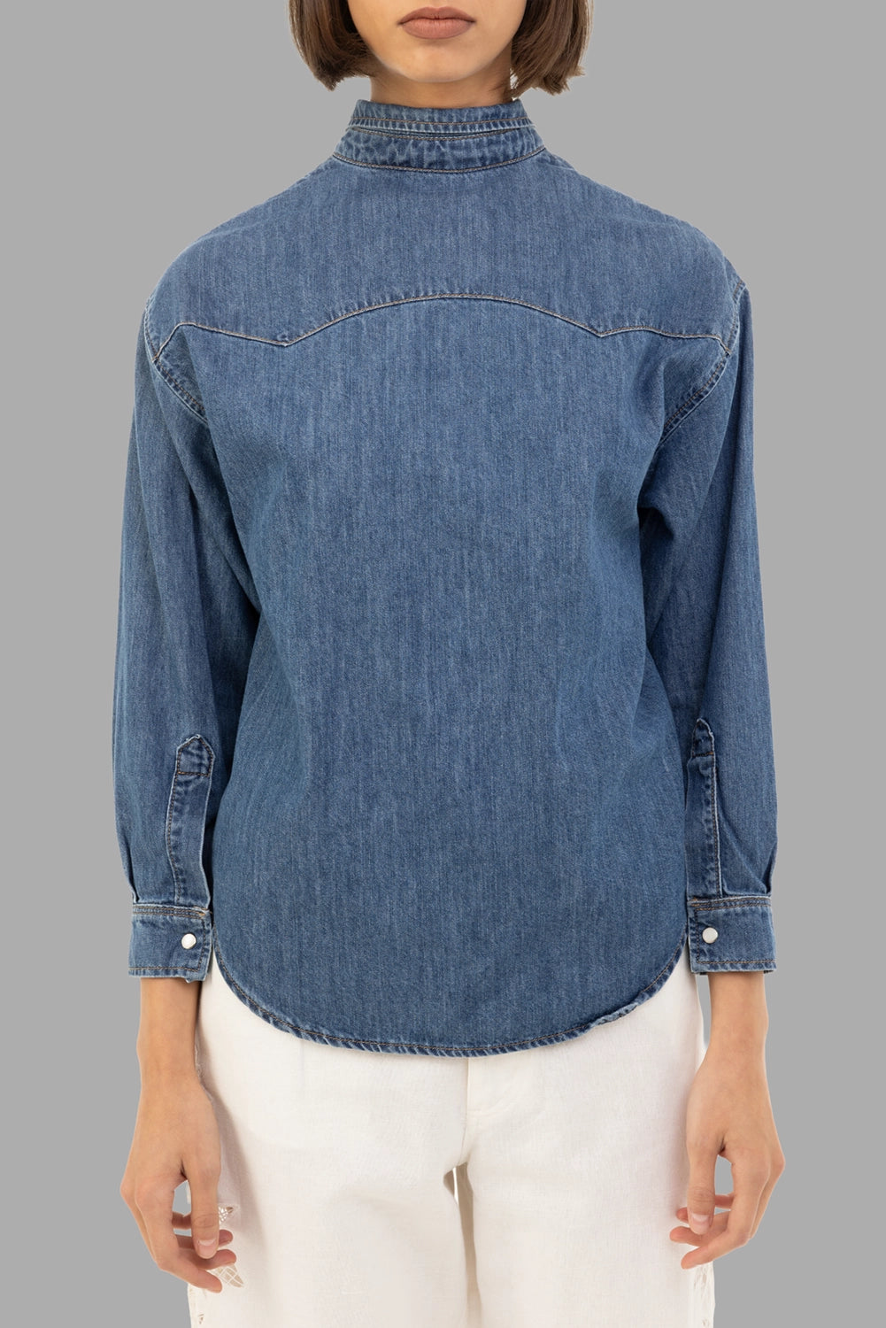A.W.A.K.E. MODE women’s denim shirt in mid blue, front view, clean front with stand collar and snap cuffs
