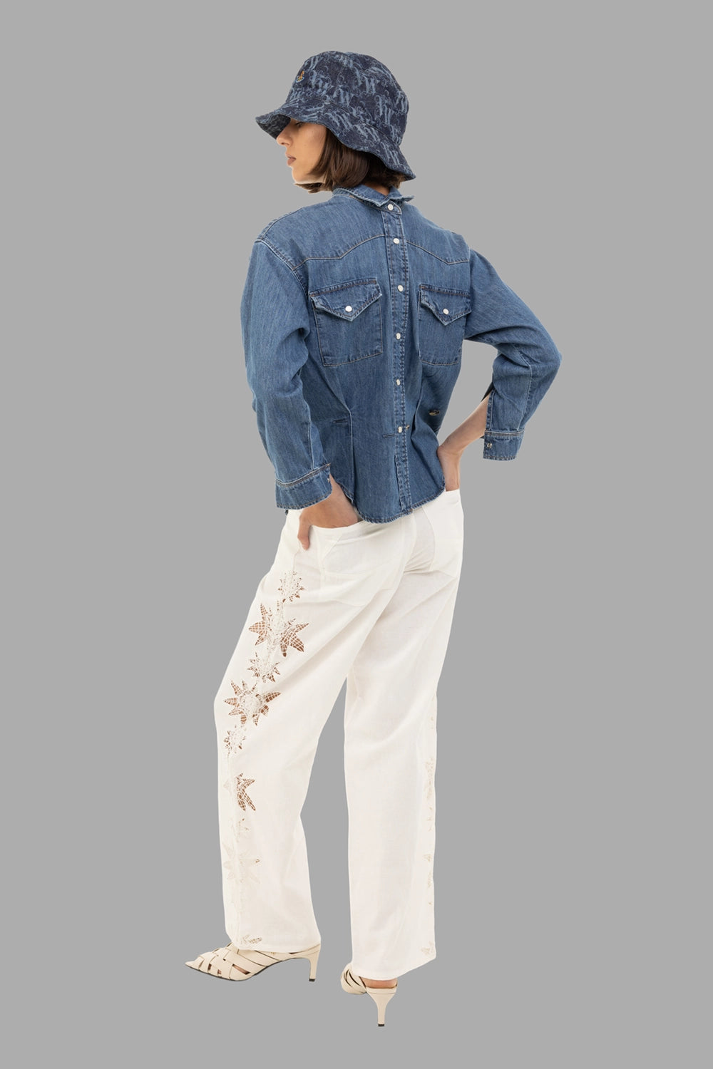 A.W.A.K.E. MODE women’s denim shirt in mid blue, full length on model, back snap placket and flap pockets
