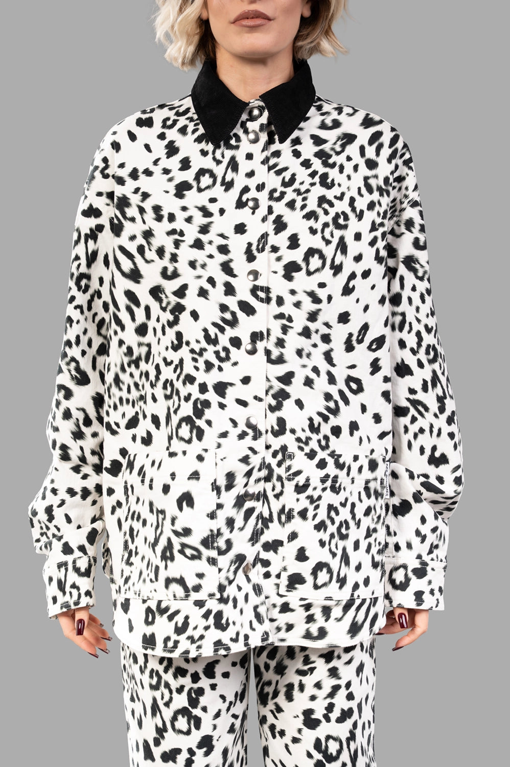 Front close-up showing snap front, black corduroy collar and large patch pockets in leopard print
