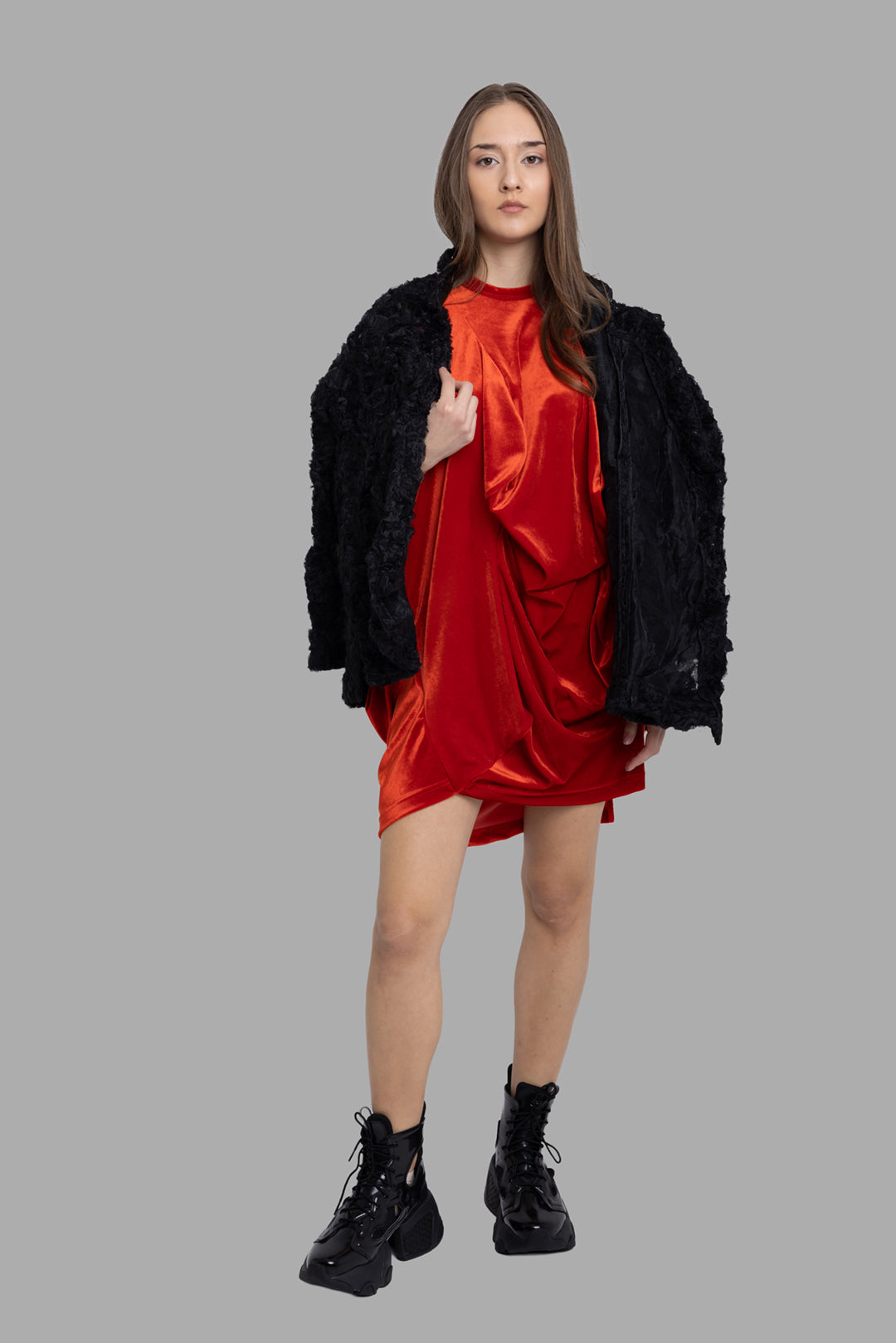 Comme des Garçons women's draped mini dress in red, on-model full length, asymmetric front folds styled with black coat.