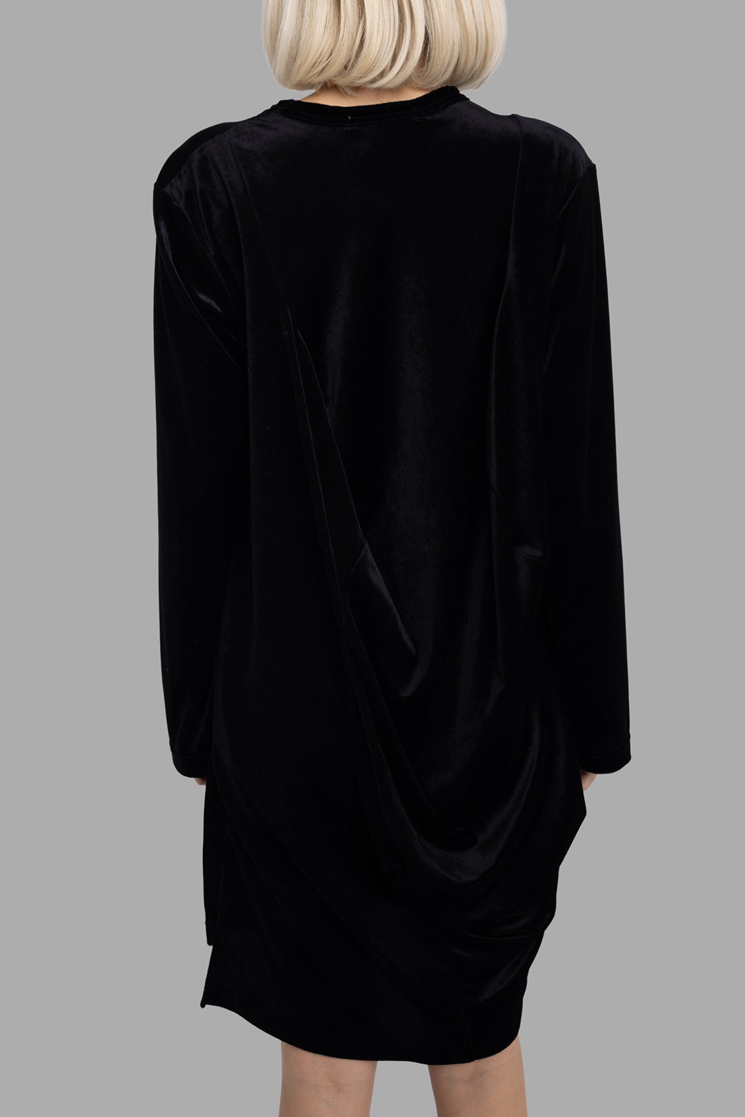 Comme des Garçons women's black draped dress, back view, smooth fabric surface with subtle rear drape detail.