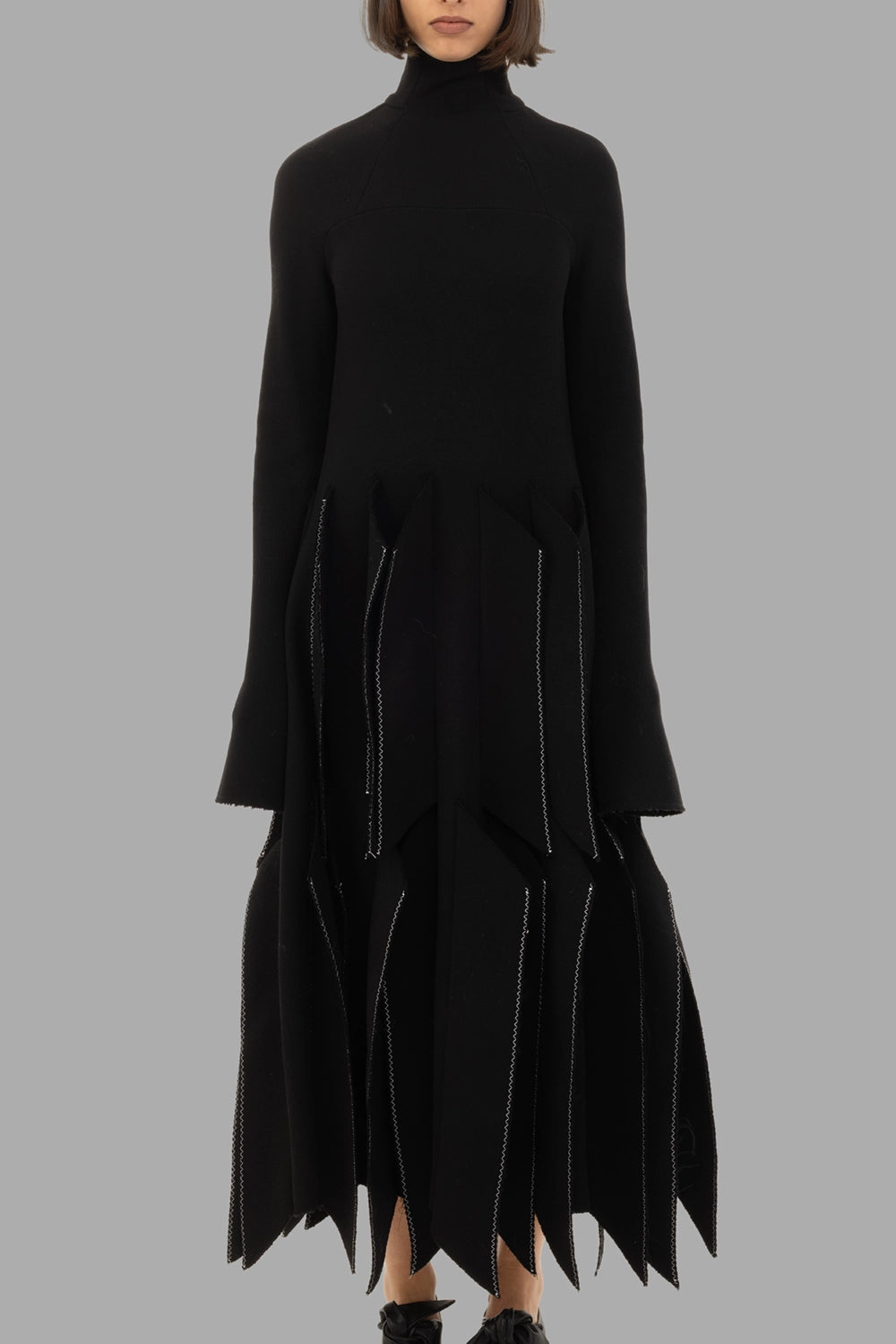 A.W.A.K.E. MODE women black dress, front view, high neck, elongated sleeves and 3D panelled skirt.