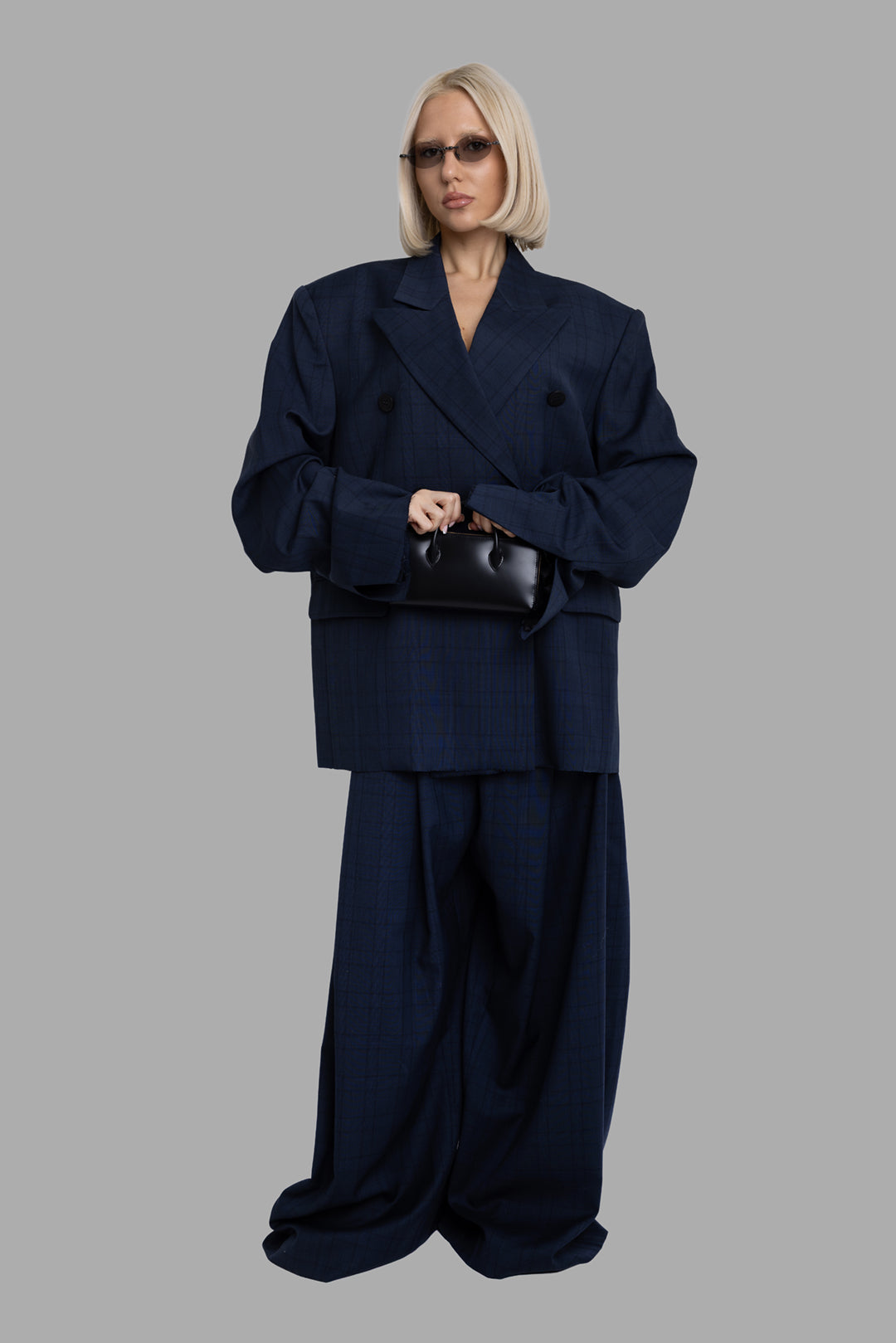 Natasha Zinko unisex folded trousers in blue check, on-model full-length front with high-rise waist and pooled wide leg