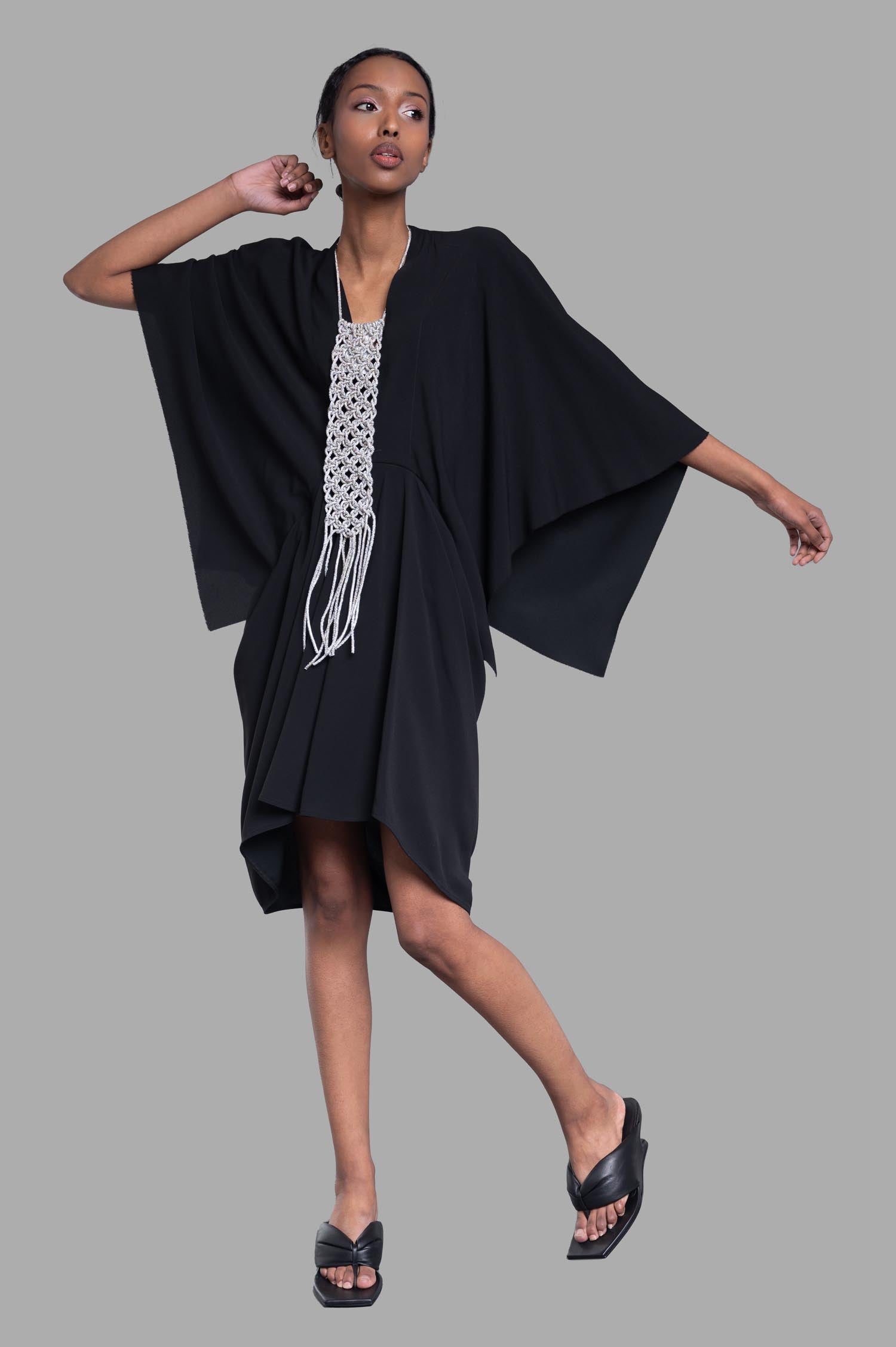 Rick Owens Half Moon Dress in black on model showcasing asymmetric sleeves and high-low hem, front view.