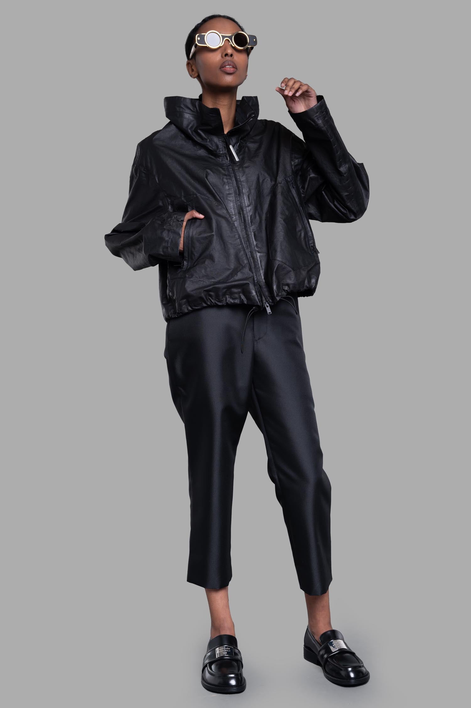 Isaac Sellam Cropped Windbreaker Jacket in black, front view on-model, featuring tube neckline and zipper detail.