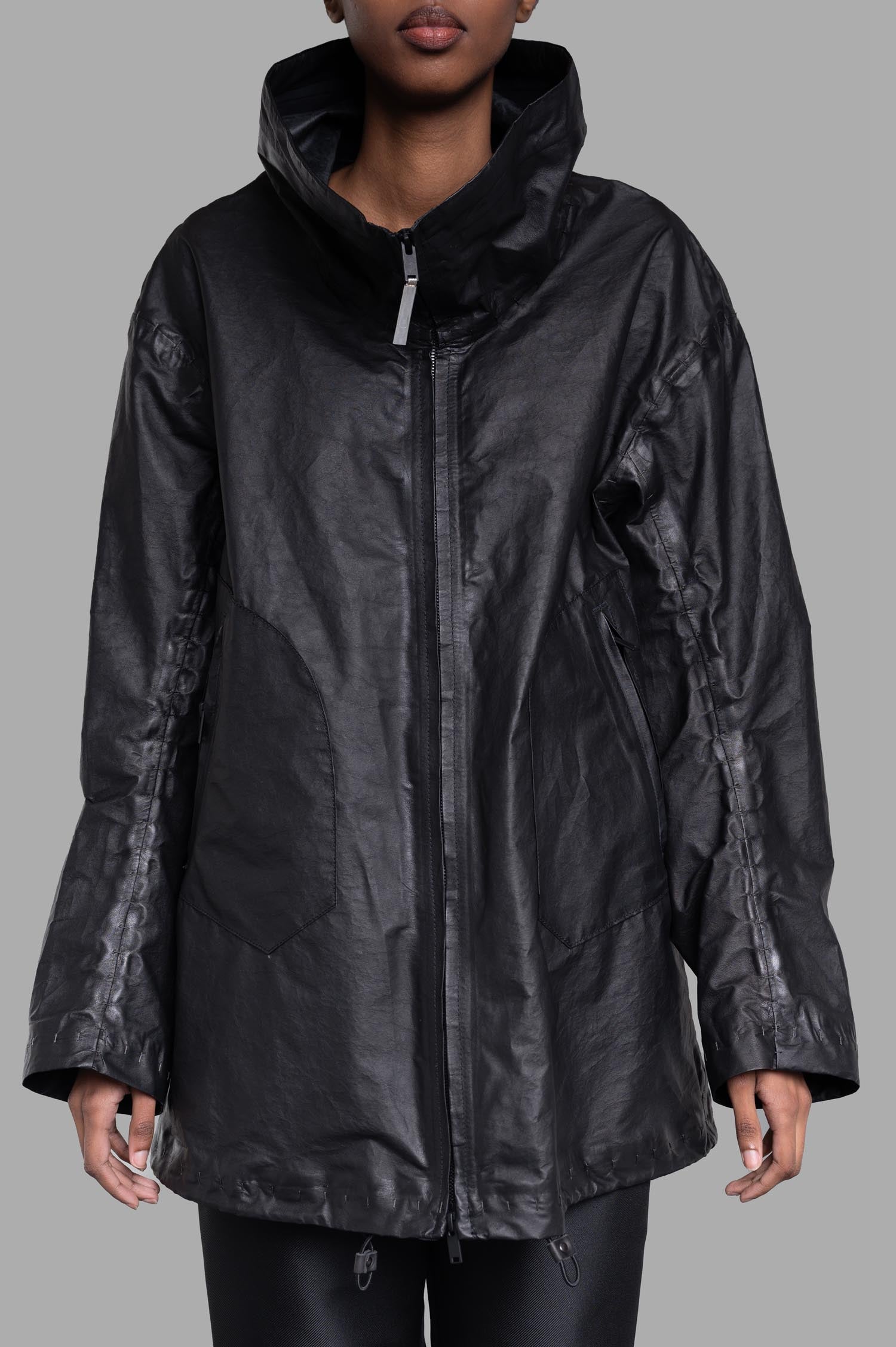 Isaac Sellam Oversized Jacket in black, showcasing a tube neckline and zipper details, with textured lambskin organza fabric.