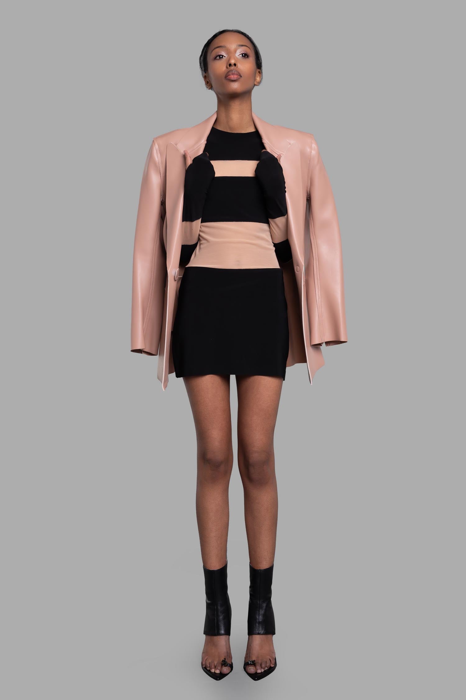 Norma Kamali Spliced Pickleball Dress styled with a beige jacket, showcasing black mesh insets and slim fit on a model.