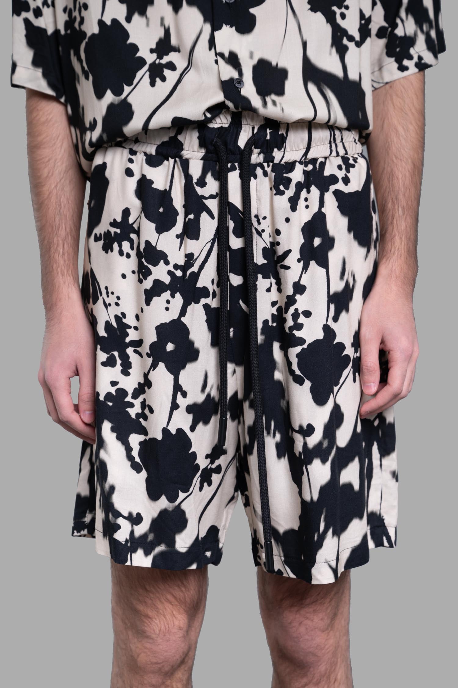 Gaëlle Paris Floral Shorts featuring an elastic waistband, adjustable drawstring, and vibrant floral design displayed on model.