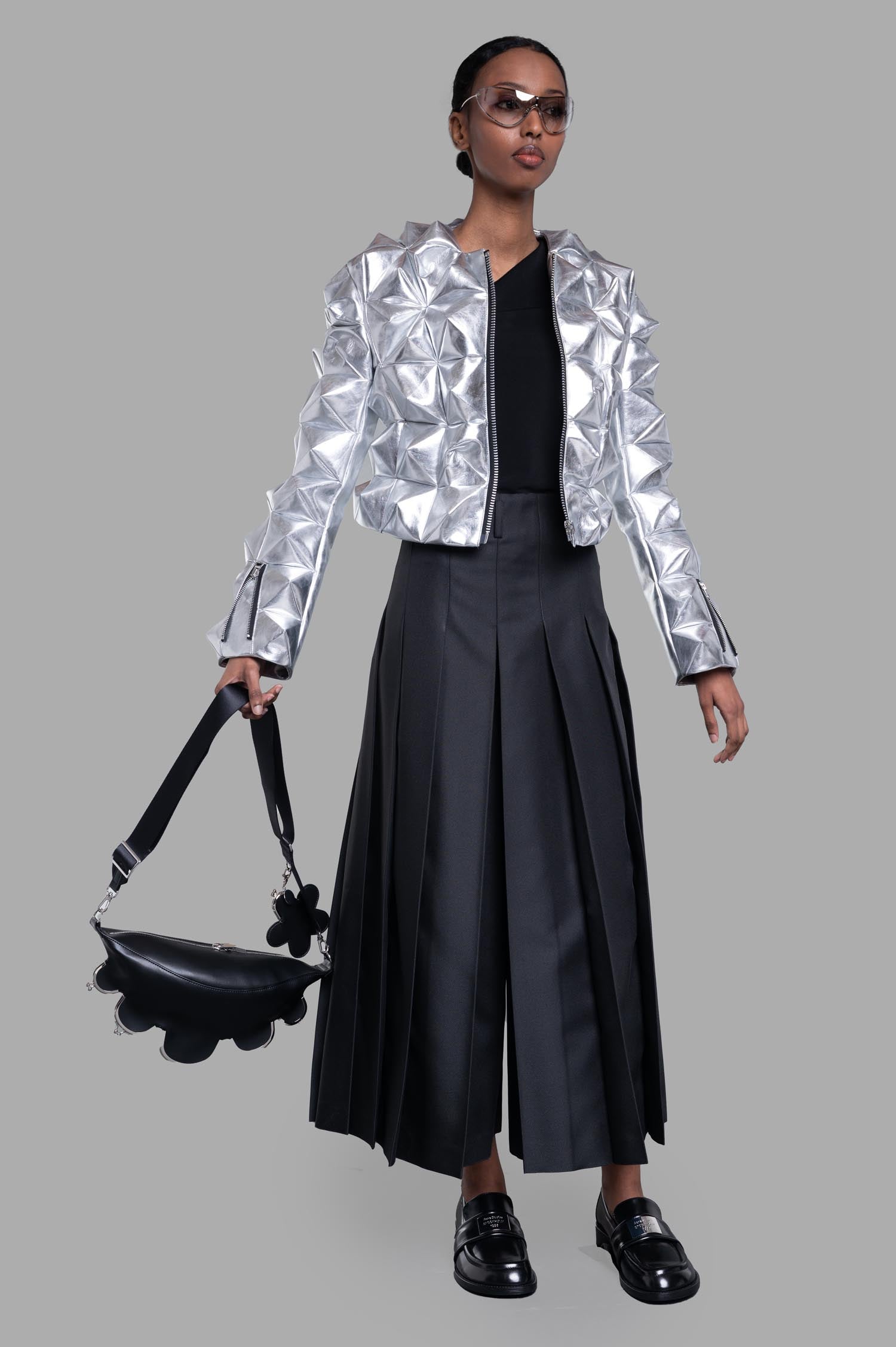 Junya Watanabe 3D-stud Jacket in Silver, on-model front view; zip front, 3D pyramid studs, styled with pleated black pants.