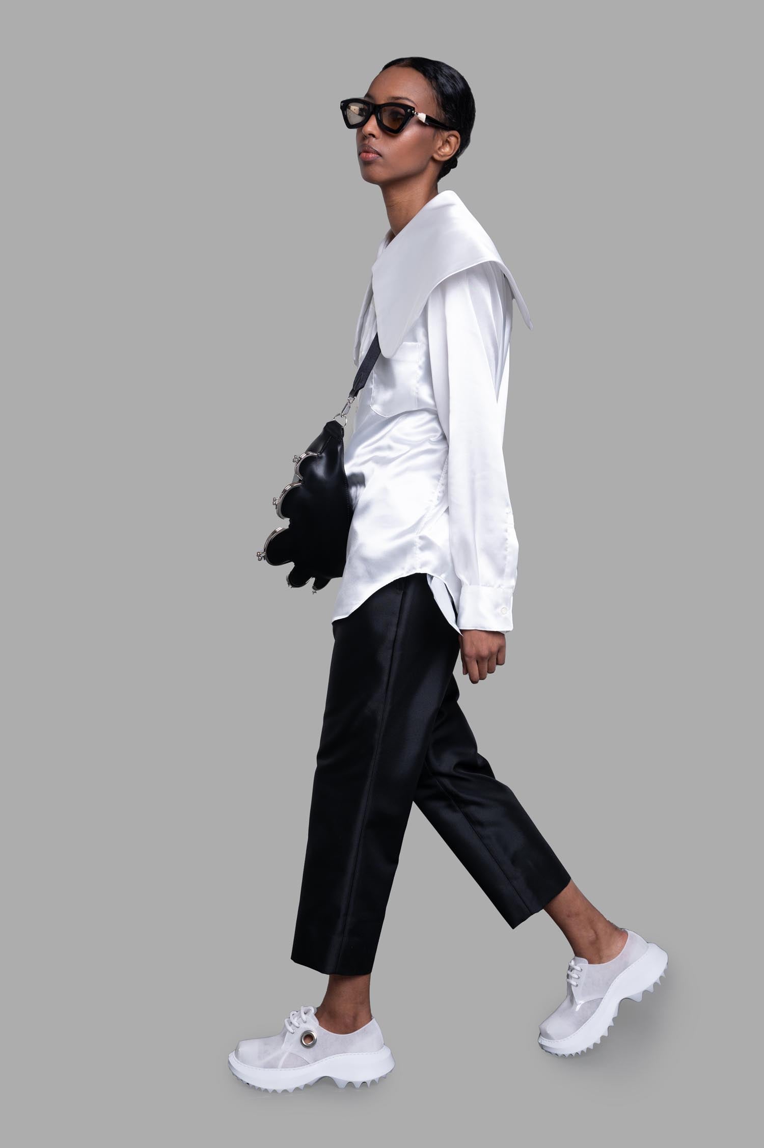 Comme des Garçons Oversized-collar Shirt in white satin, side view on model with black pants and white shoes.