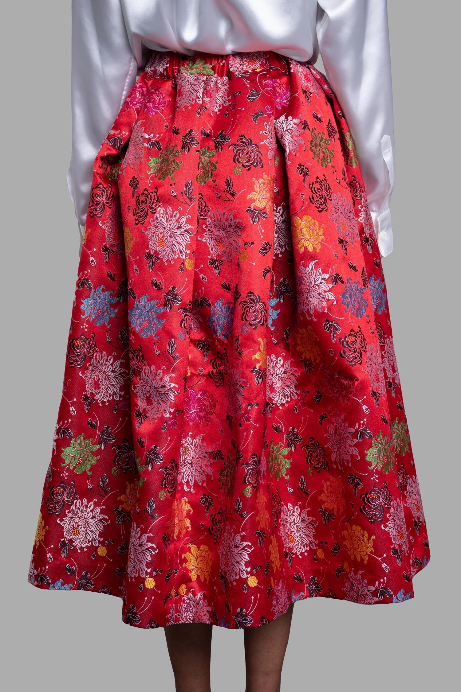 Comme des Garçons Floral-jacquard Midi Skirt in red, showcasing vibrant floral patterns and elegant elastic waistband detail.
