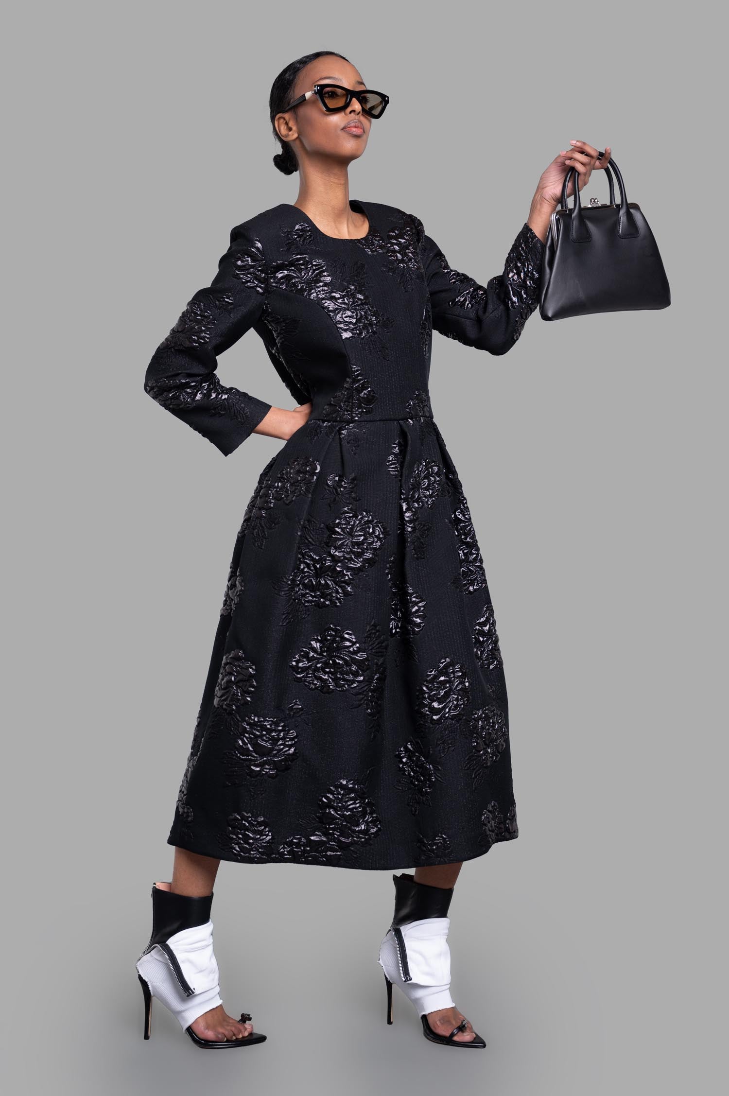 Comme des Garçons black structured floral dress worn on-model, showcasing textured 3D florals and elegant silhouette.