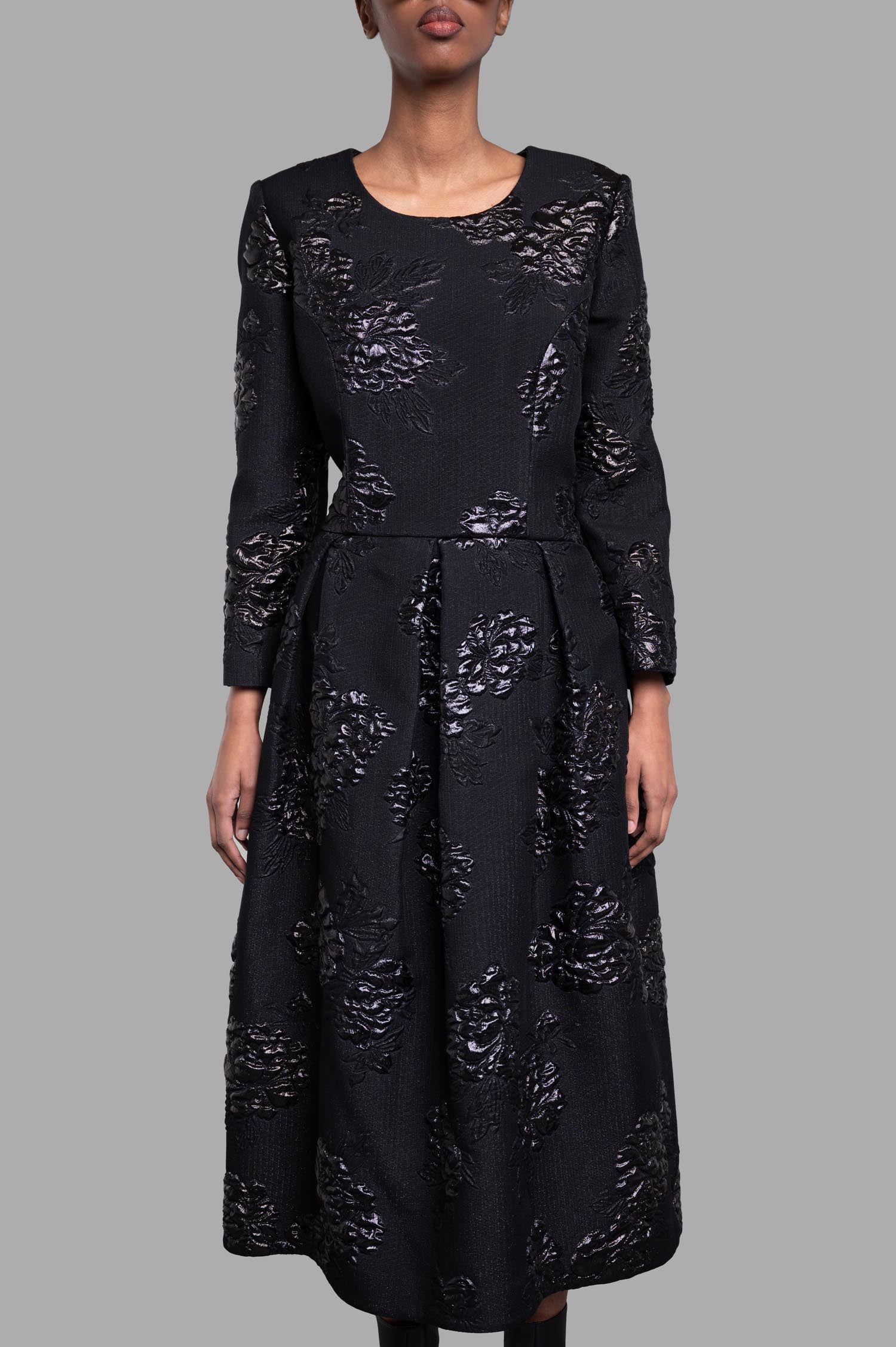 Comme des Garçons Structured Floral Dress features 3D floral texture, shown in black with long sleeves on a model.