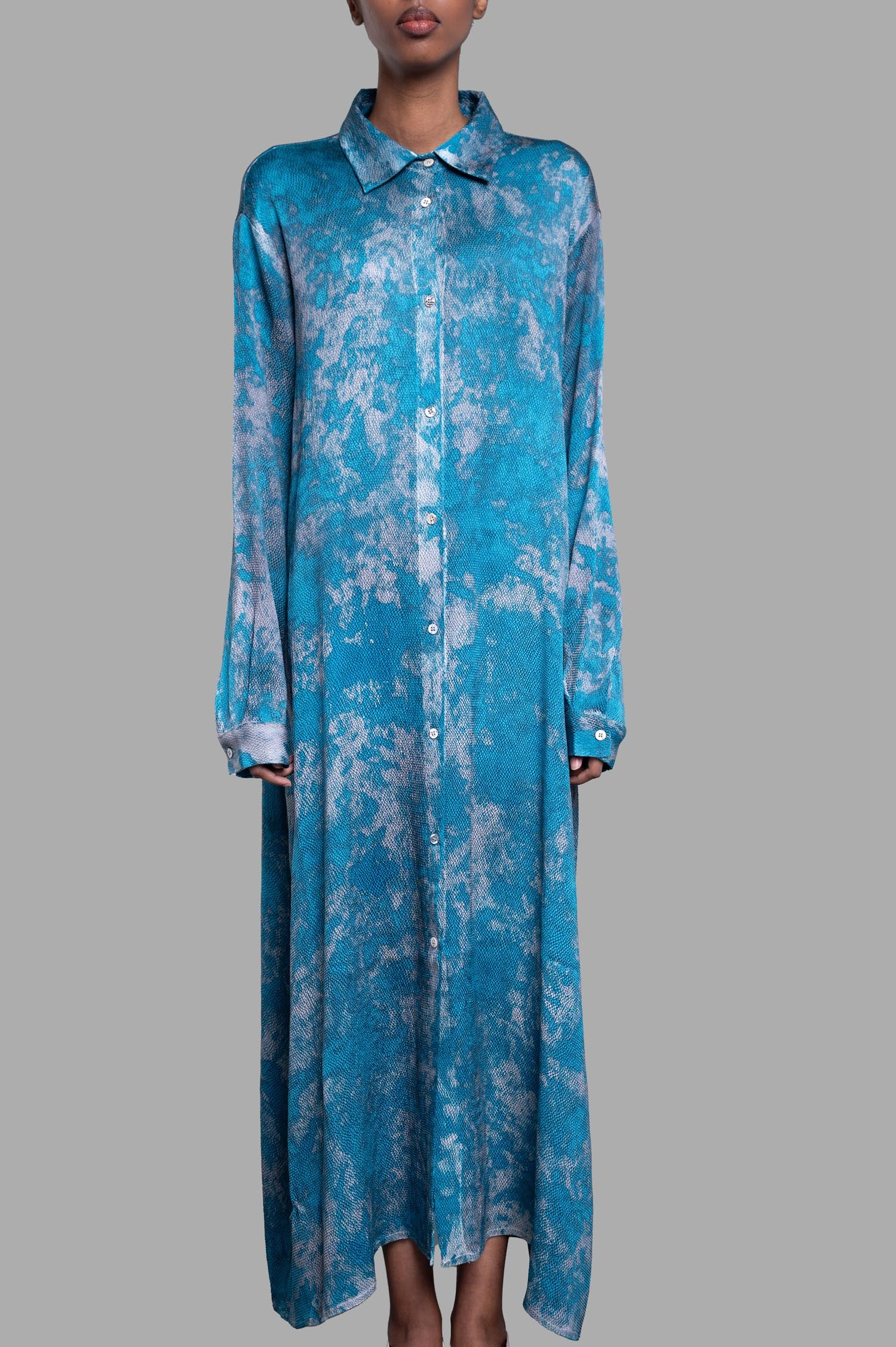 Avant Toi Abstract-print Shirt Dress shown on model, featuring a vibrant blue and gray pattern, buttoned front and long sleeves.