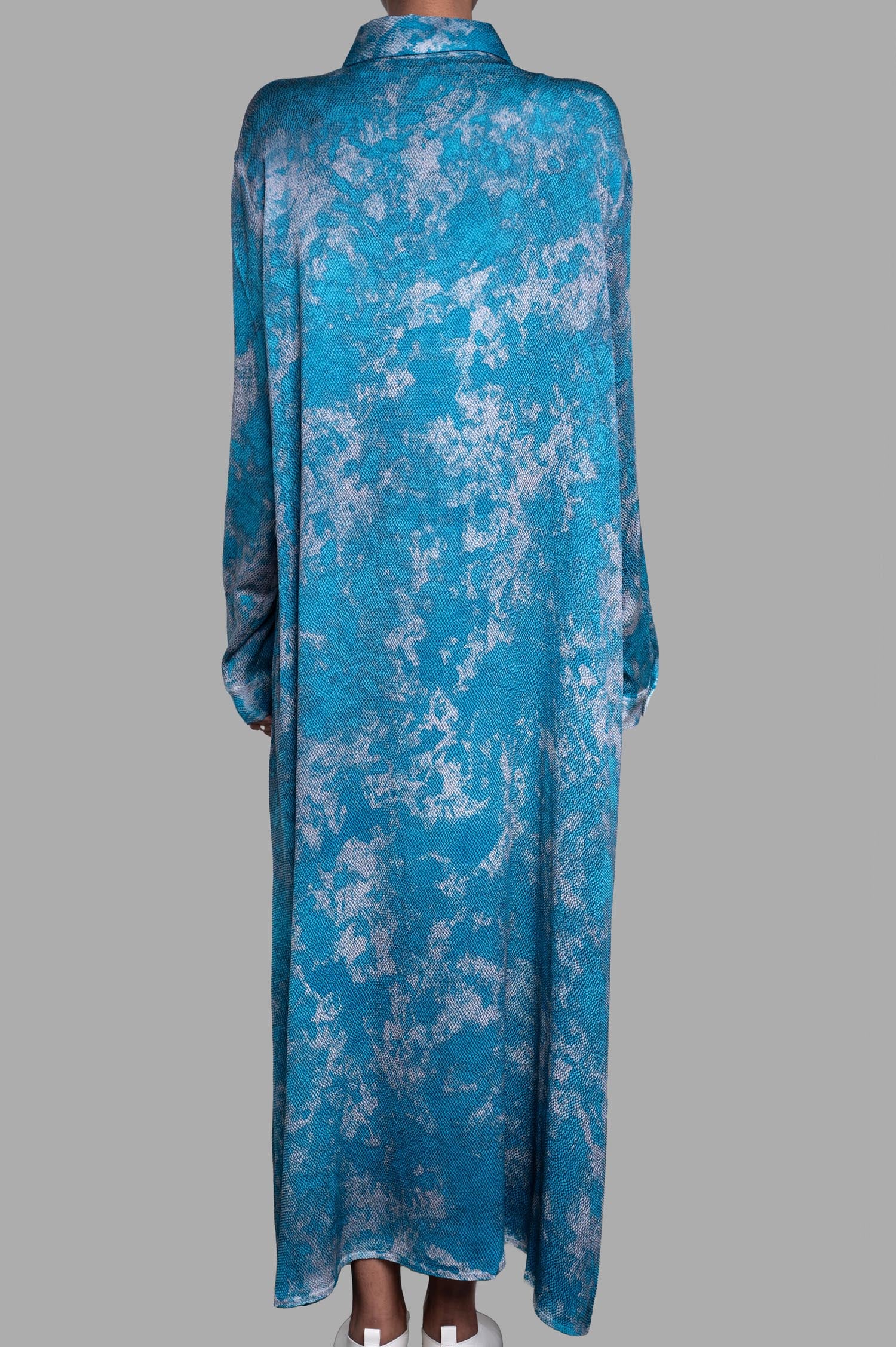 Avant Toi Abstract-print Shirt Dress, featuring a flowing blue design seen from the back on a model, styled elegantly with white shoes.