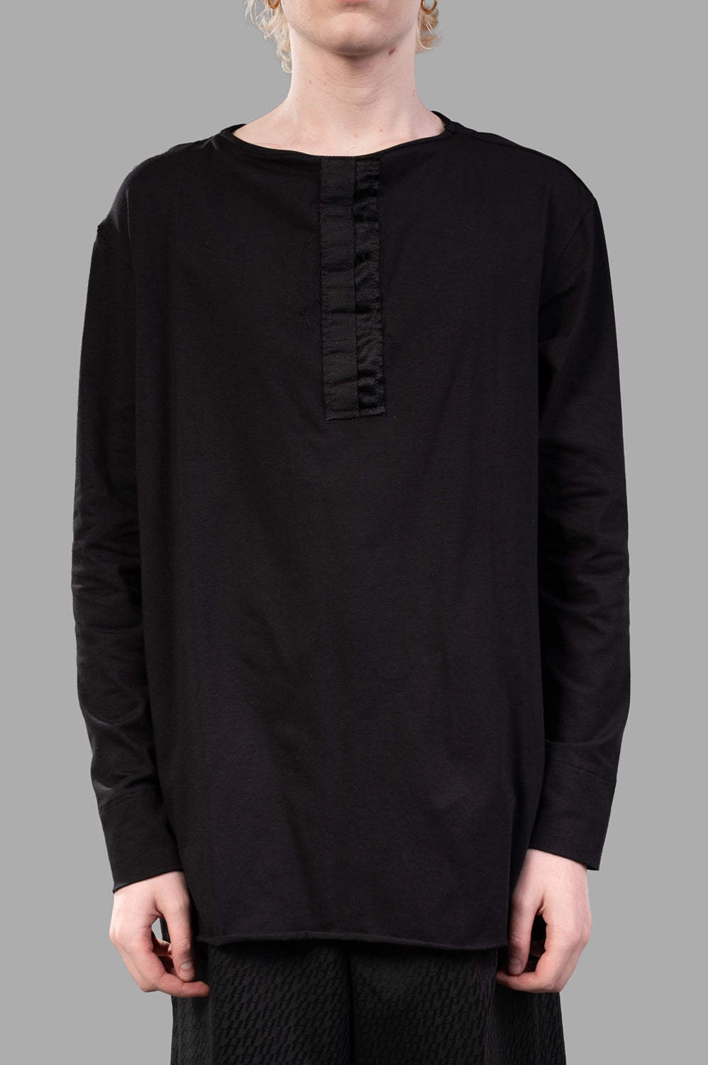 Front close-up showing crew neck and tonal satin placket; soft jersey texture