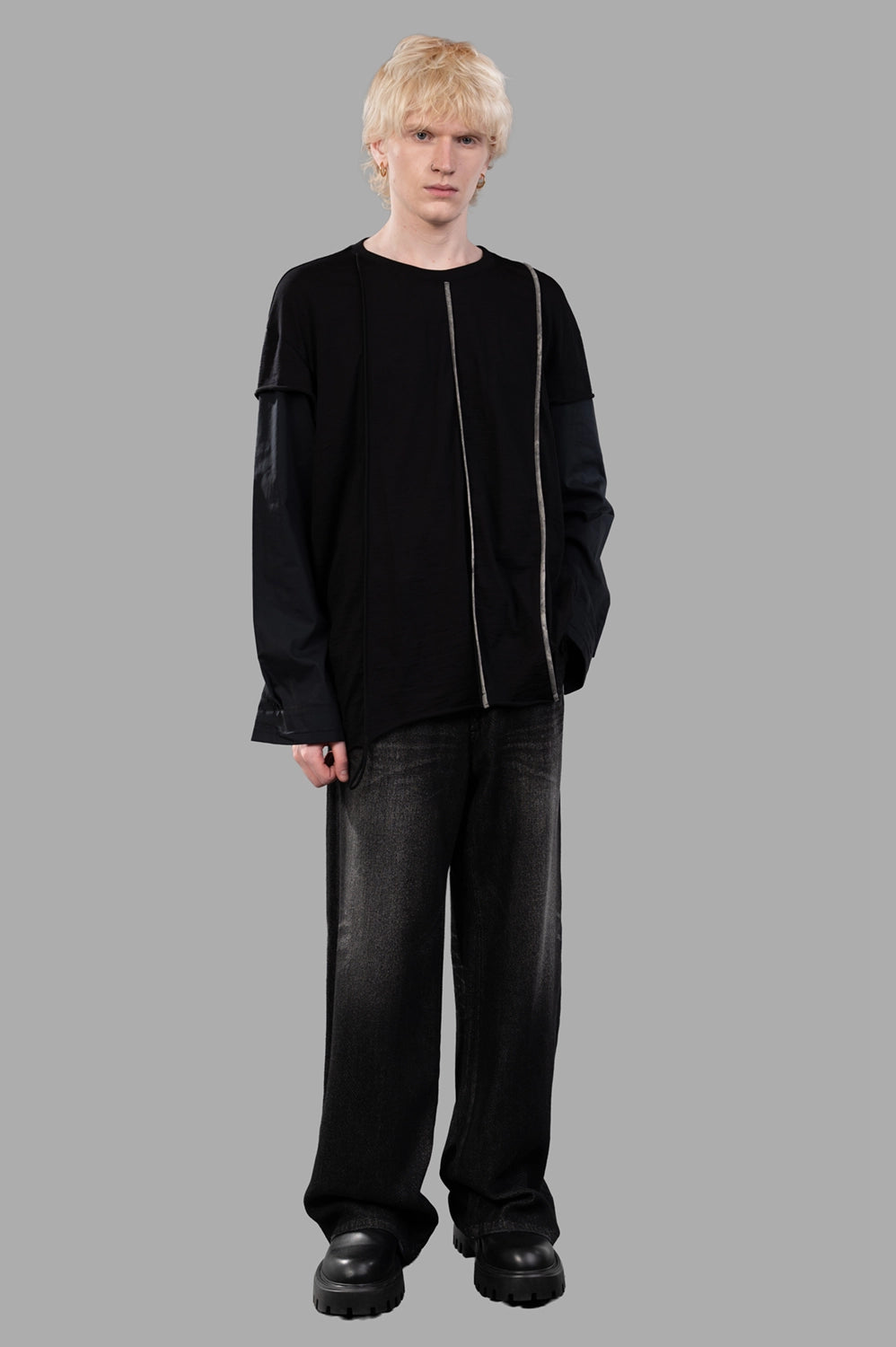 Full-length view of black long-sleeve tee with layered sleeves and contrast vertical trim; relaxed fit silhouette